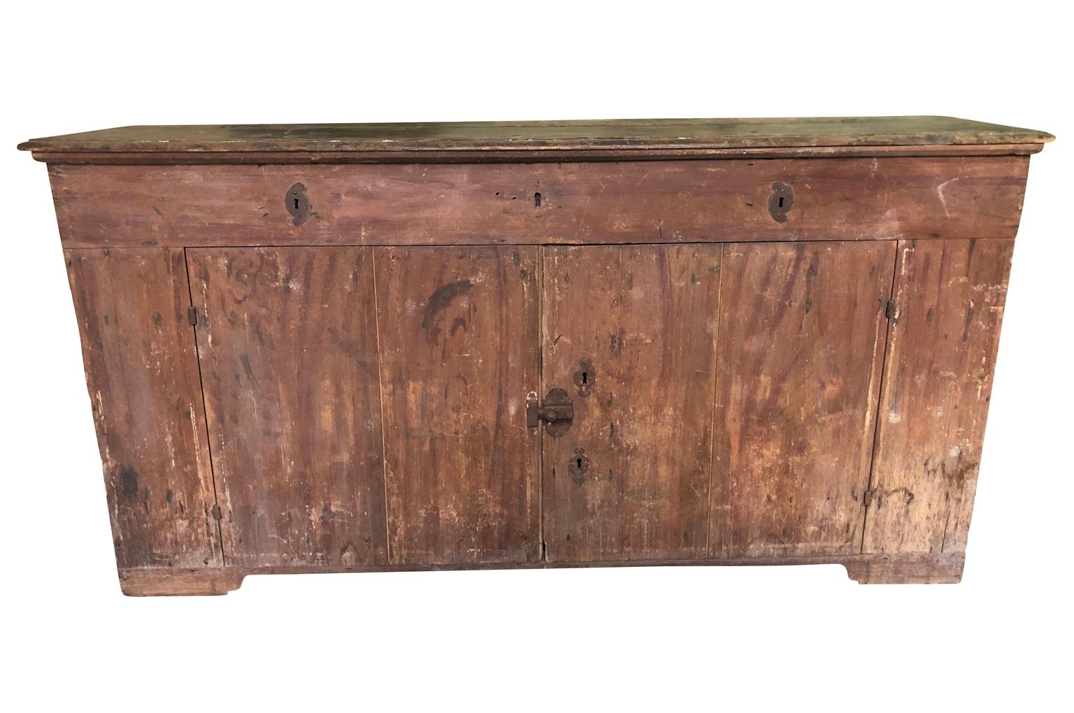 A wonderful and primitive credenza from Northern Italy in painted wood with a top that lifts over double doors. Beautiful.