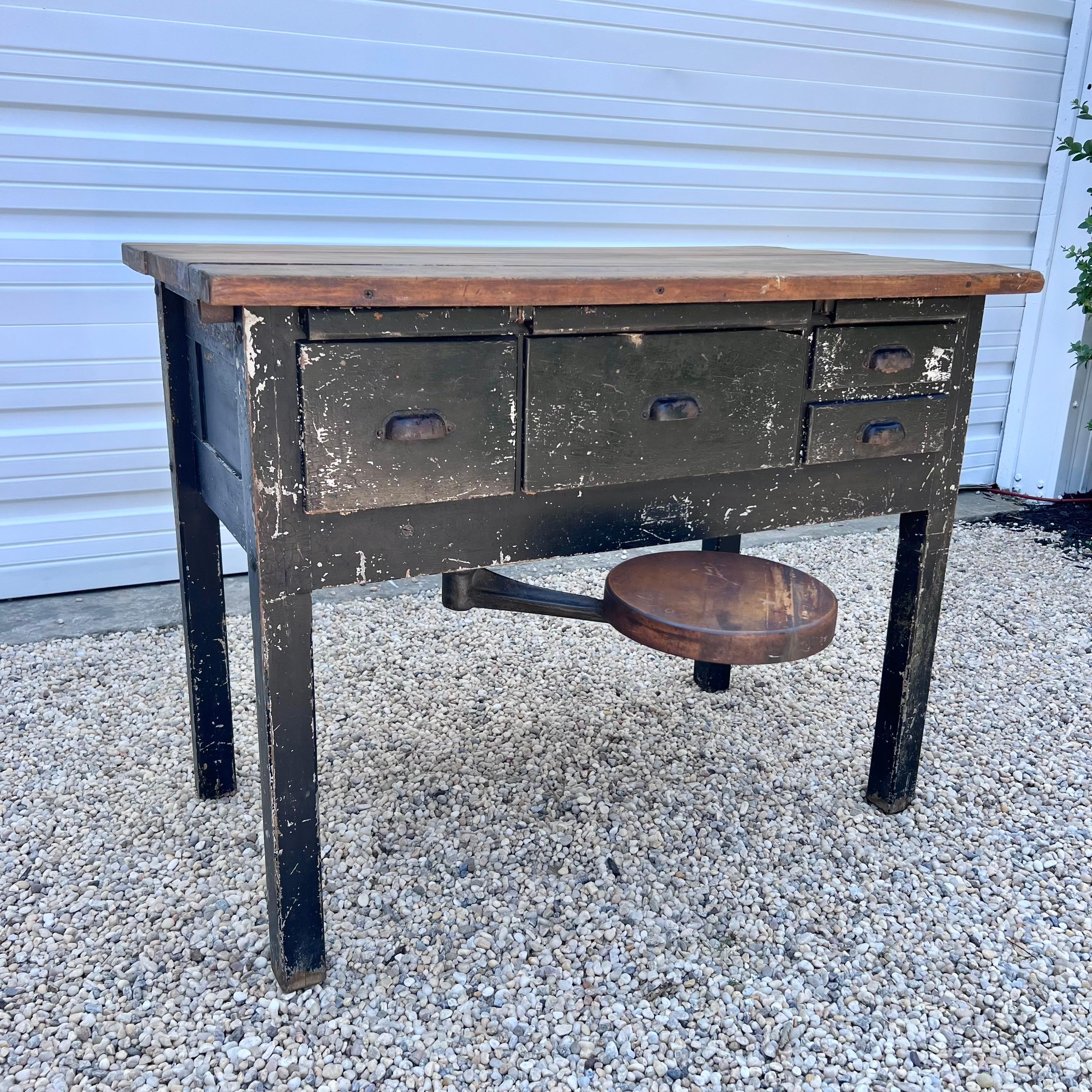 Incredible primitive Americans desk in a beautiful black paint with heavy patina and raw wood accents. Four pull-out drawers across the front of the desk as well as three individual pull out writing boards that tuck neatly back into the desk.