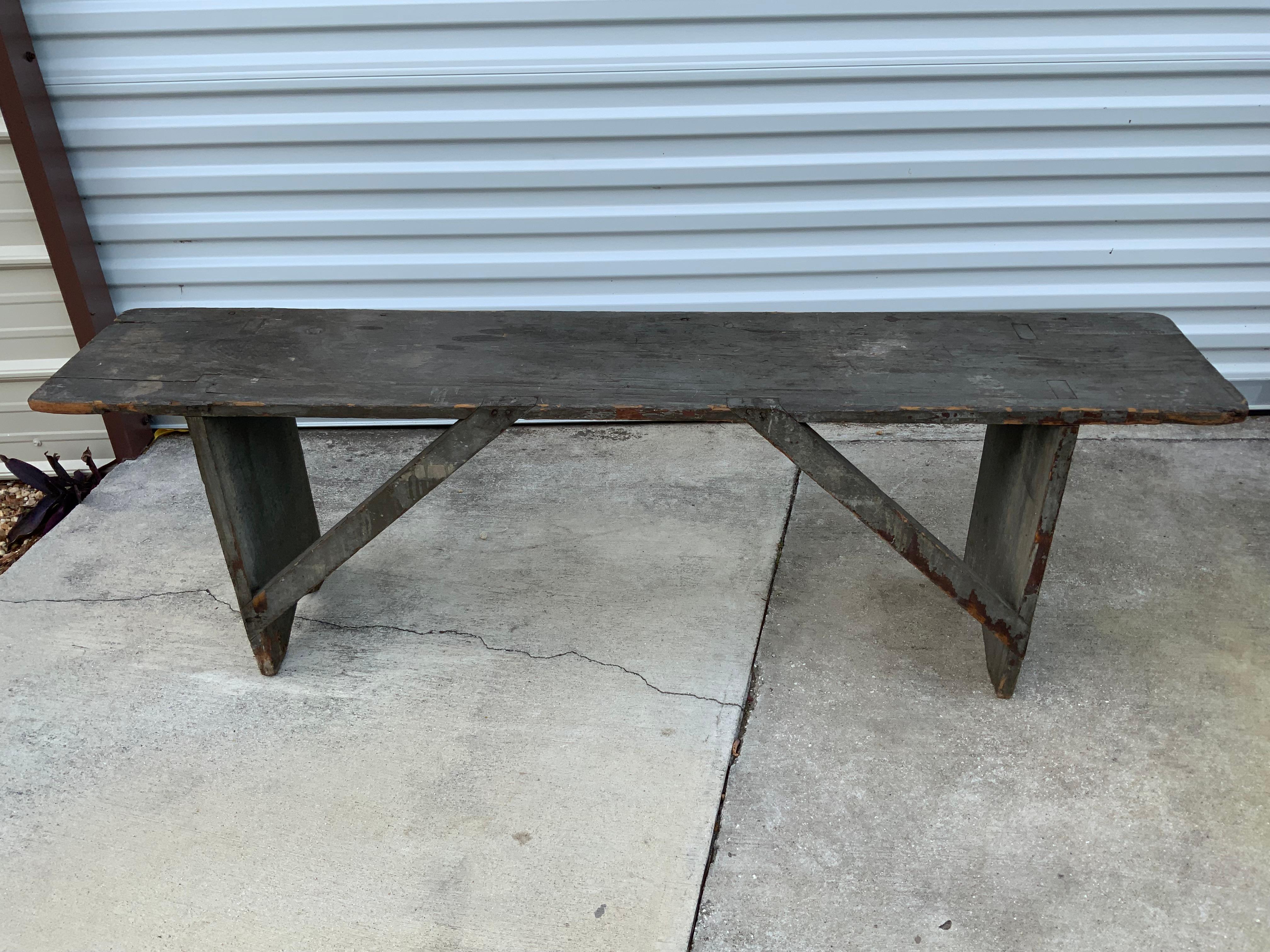 Exceptional example of an original condition 19th century Pine bench in old grey paint over the original red. A very nice tight solid bench in good to excellent condition with no repairs or replacements. Base supports are mortised into the top,