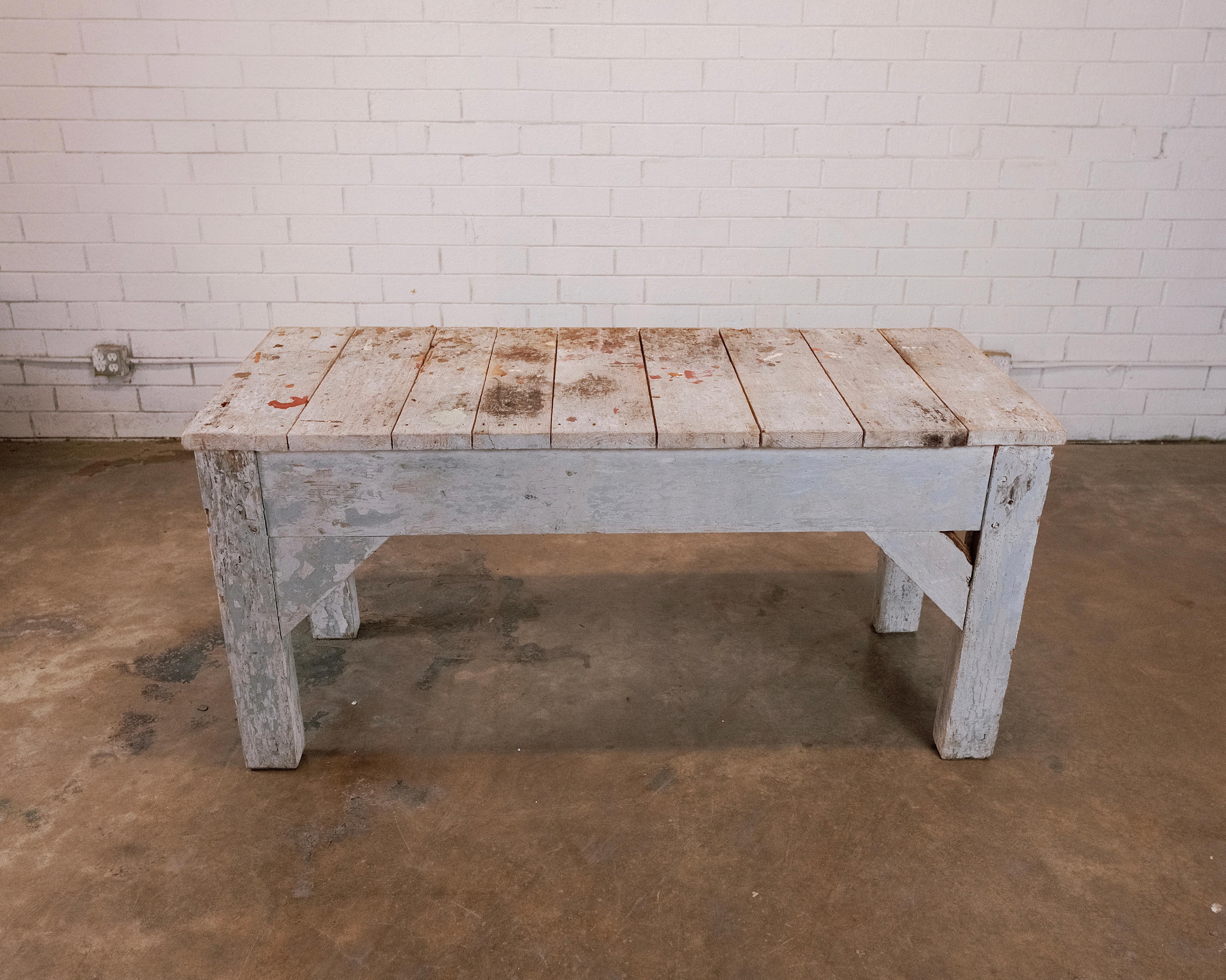 Primitive Painted Blue Workshop Table, a vintage piece that emanates old-world charm and character. Crafted with a utilitarian purpose, this table showcases a hand-painted blue finish that has gracefully aged over time, adding a layer of