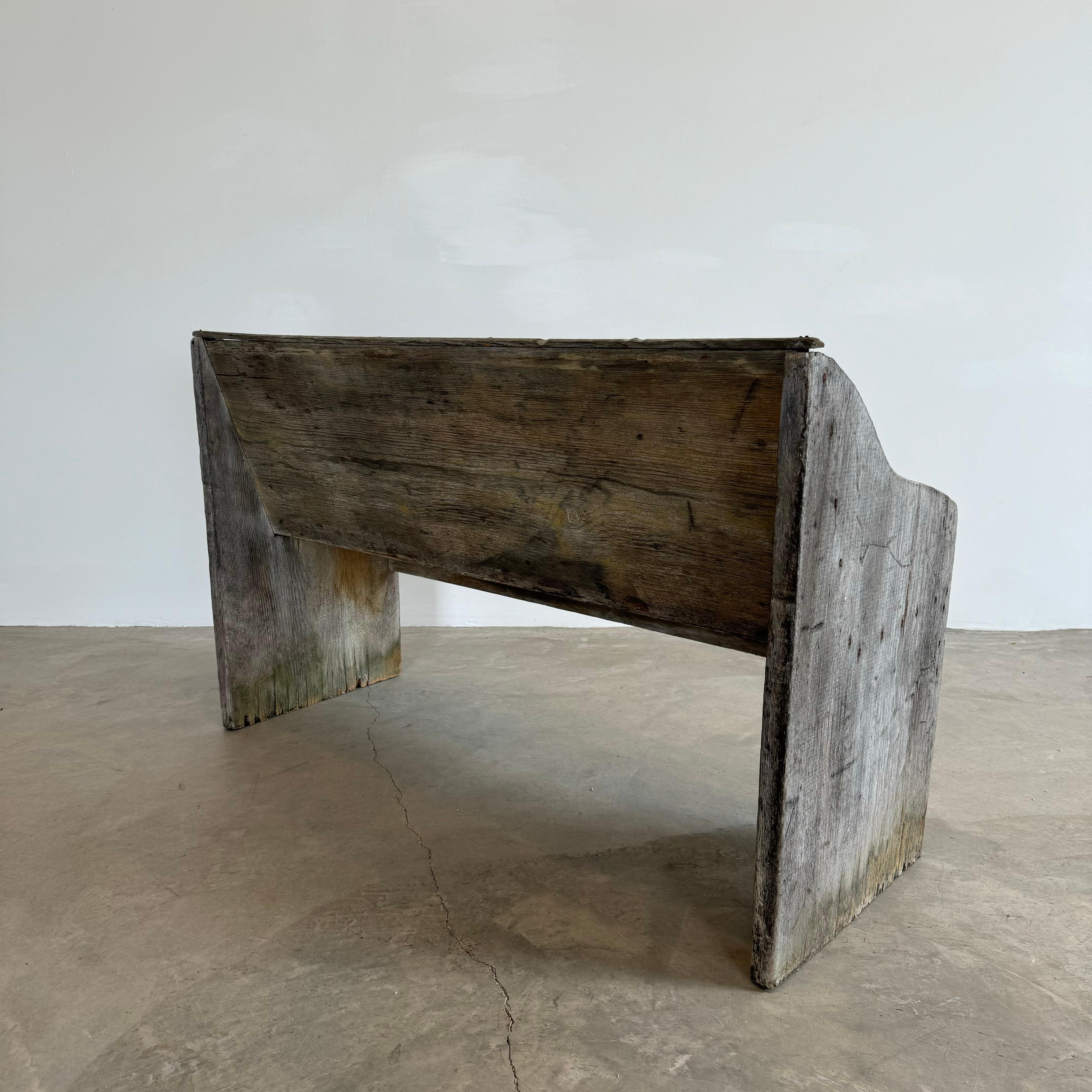 Incredible Pine chapel bench from the late 1800s. Thick panels of solid pine were used to construct this piece. After years of use and natural exposure the bench developed the one of a kind patina seen here. This bench is held together with small