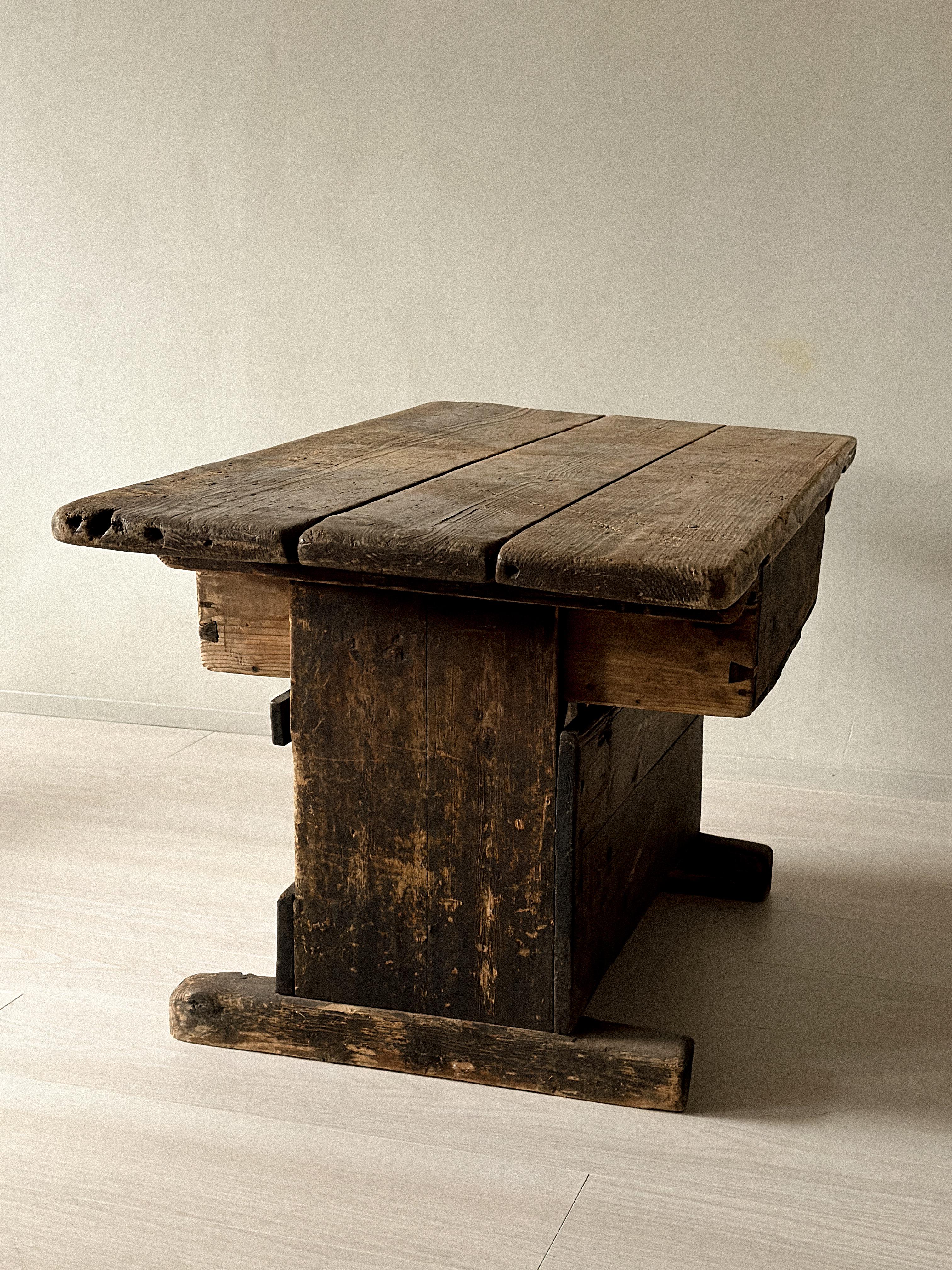 Originally used as a shoemaker’s table in rural Scandinavia, this early 19th-century pine piece carries the marks of long use. The worn surface and faded red drawer front reveal its working history, while the simple, sturdy construction gives it a