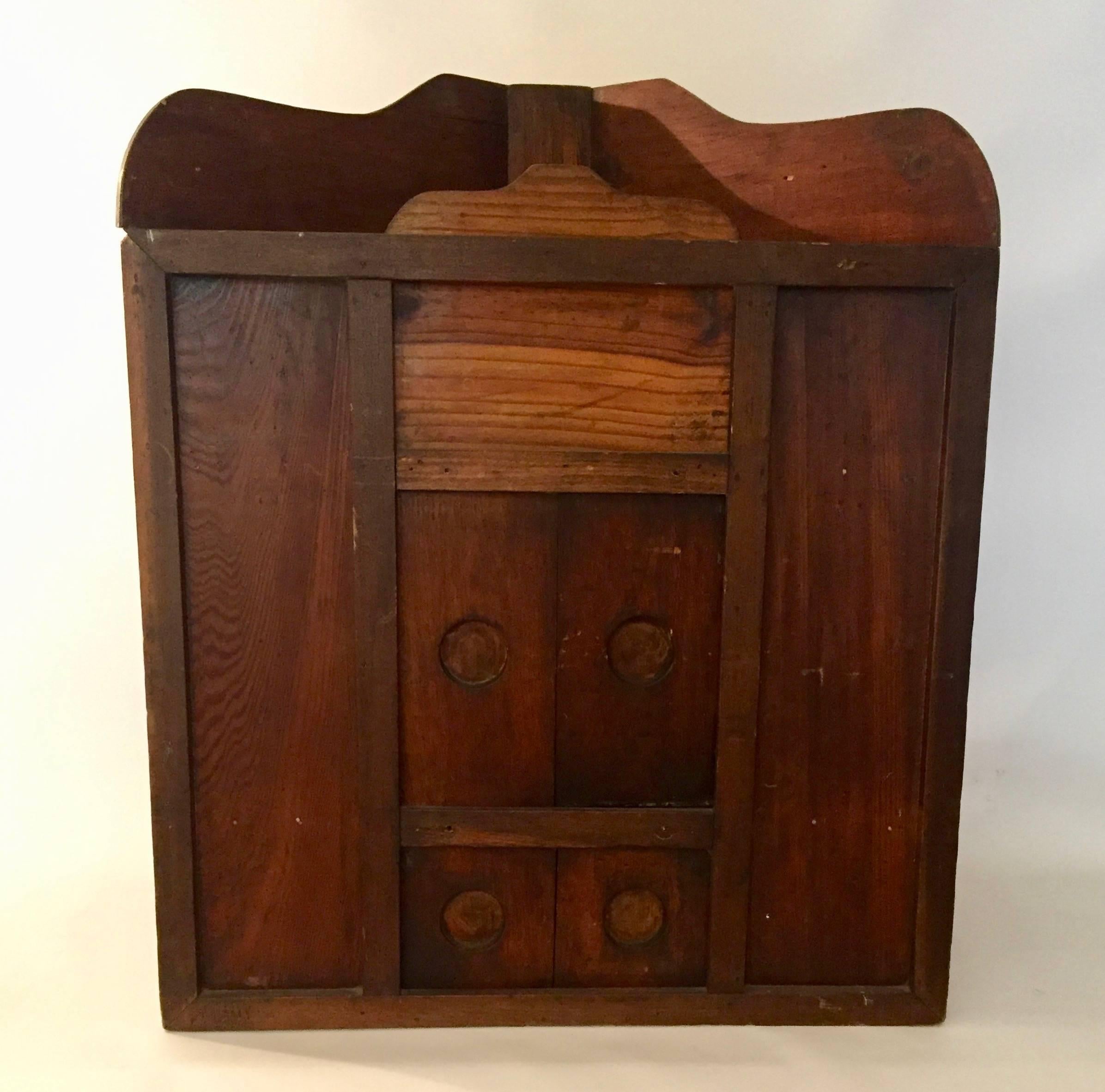 Handmade 19th century pine primitive corner cabinet. It's a bit of an oddity possibly meant to obscure precious items. There is a trick to opening the doors. The two sets of doors almost seem spring loaded, but they are not. The doors fit into