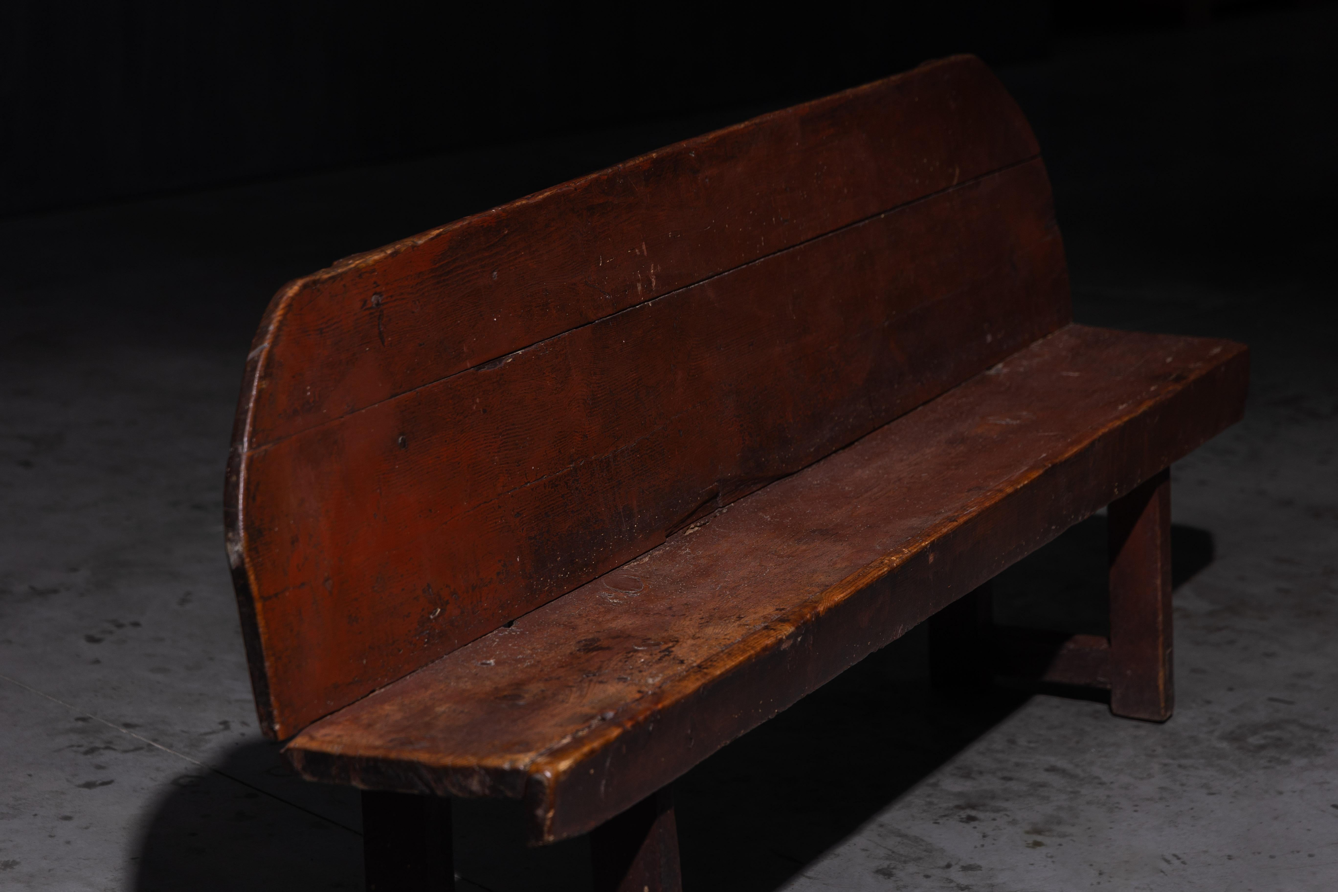 Questa panca rustica cattura l'onesta semplicità dell'artigianato rurale. Lo schienale arrotondato e la patina del tempo parlano di generazioni passate, dove l'utilità incontrava il carattere. Robusta e priva di orpelli, la panca porta i segni