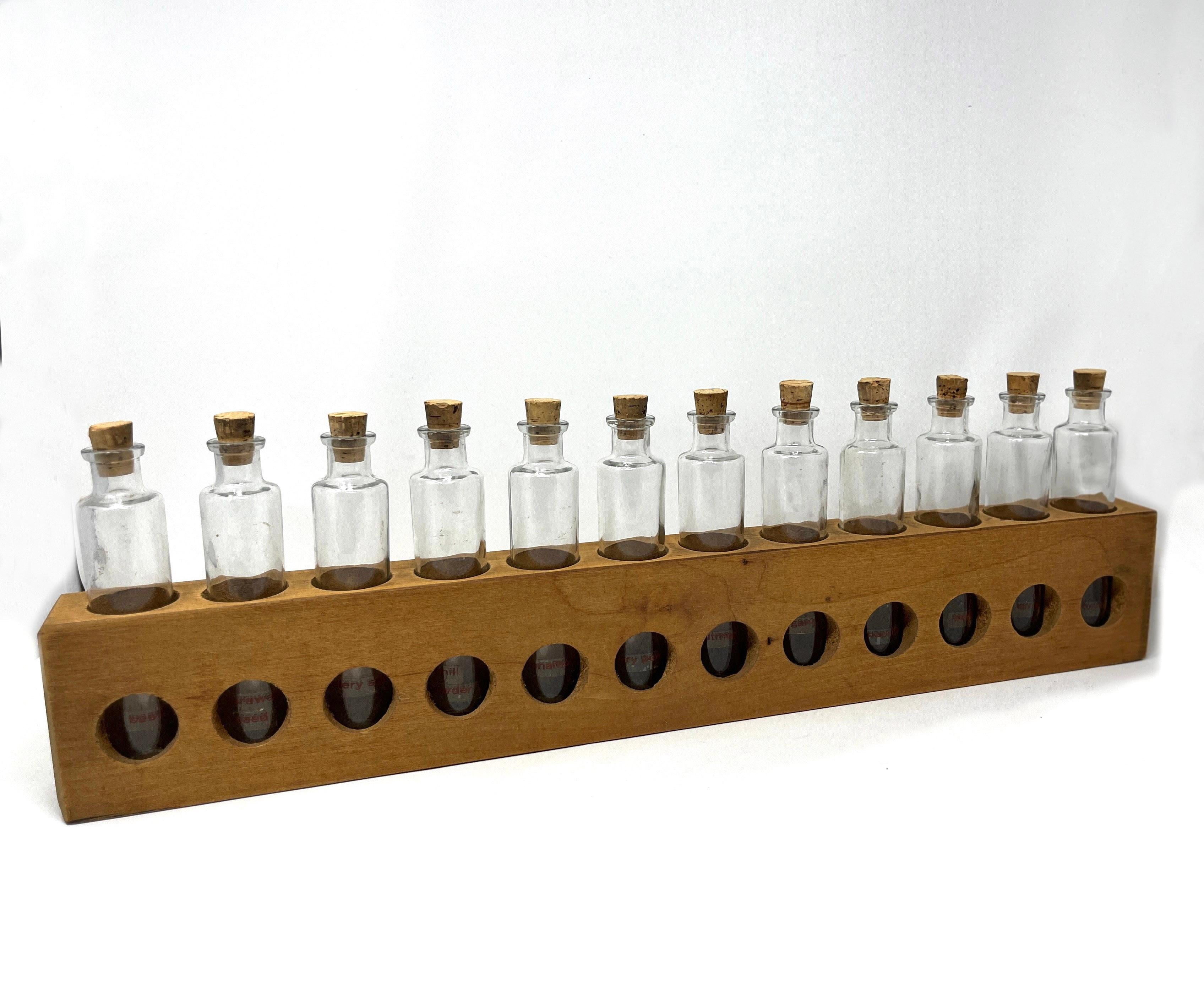 Charming handmade pine spice rack with 12 excellent tall, thin glass jars. Excellent proportions with hardware affixed to hang on the wall. Fabulous for its intended use as as storage for hardware, beads or other craft supplies. 

Each jar has a