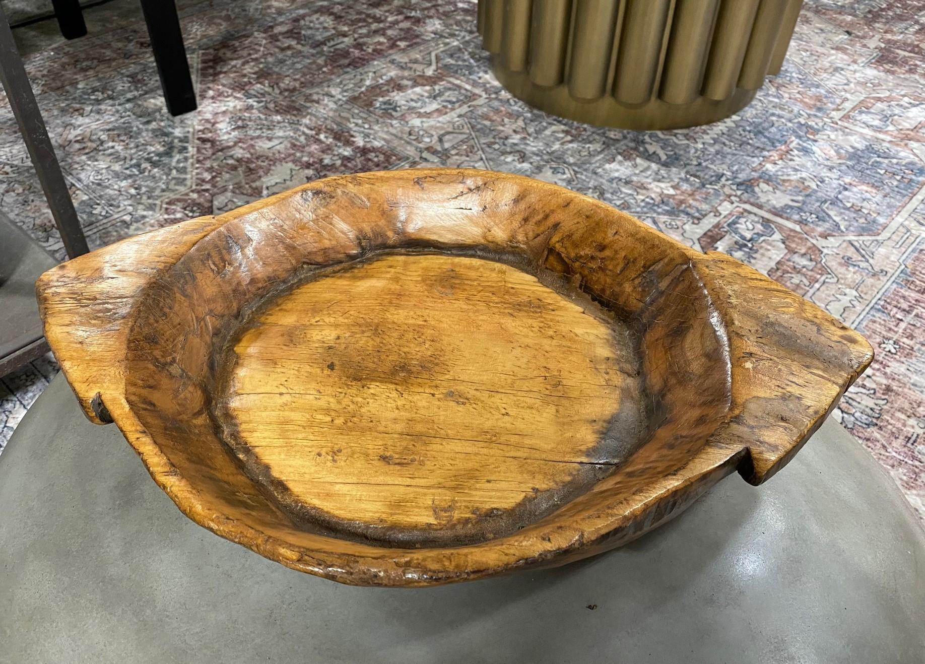 A wonderful large Folk Art carved bowl with beautiful natural wood grain and glowing colorful patina acquired with age. This piece has a very organic, Wabi-Sabi feel to it. The pointed handles are an unusual, unique touch. 

From a collection of