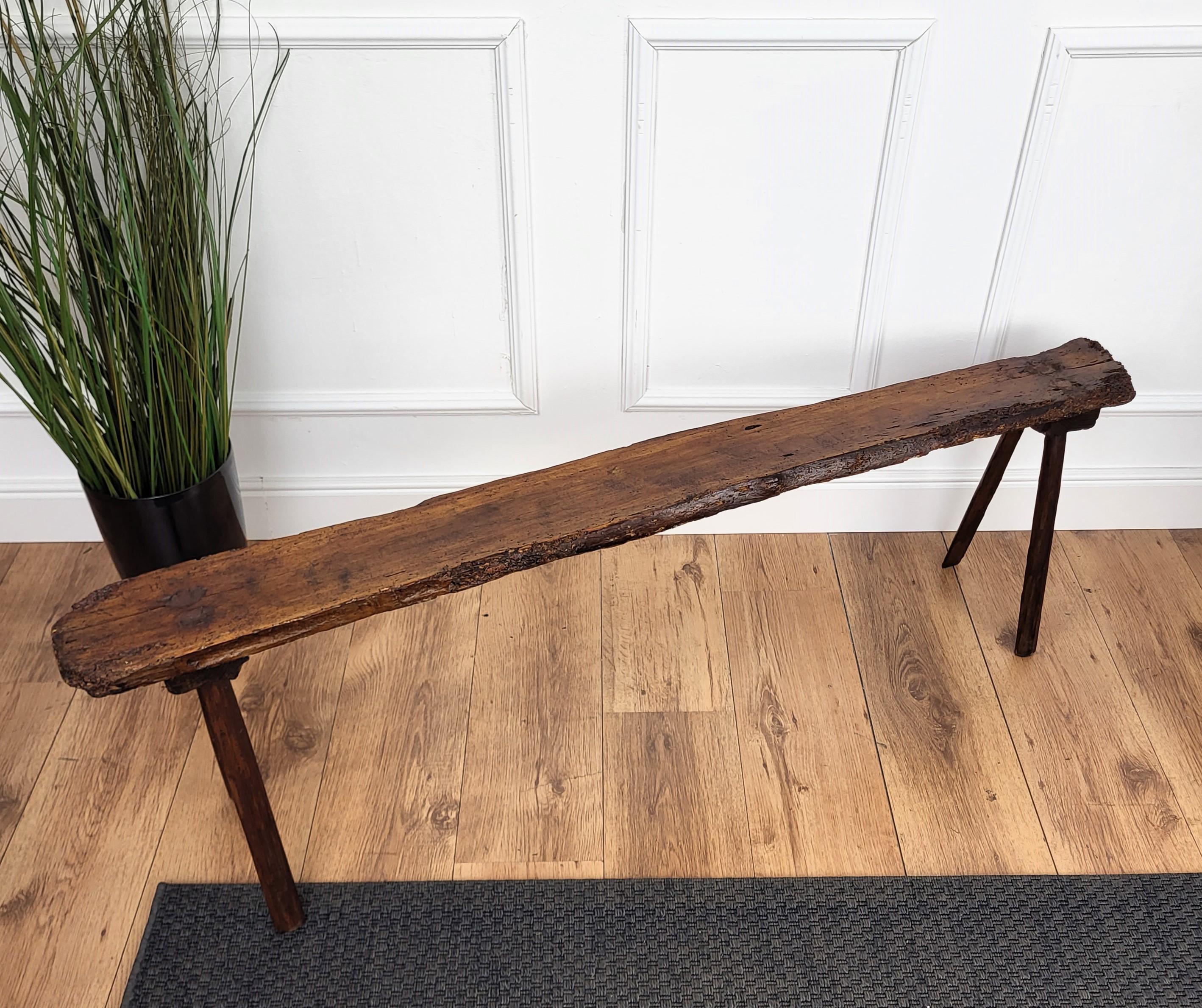 Beautiful Italian rustic primitive country wooden bench, with typical legs in original aged natural color giving the rich and beautiful patina that makes it look wonderful in every interior. This piece is in the rustic primitive spirit of organic