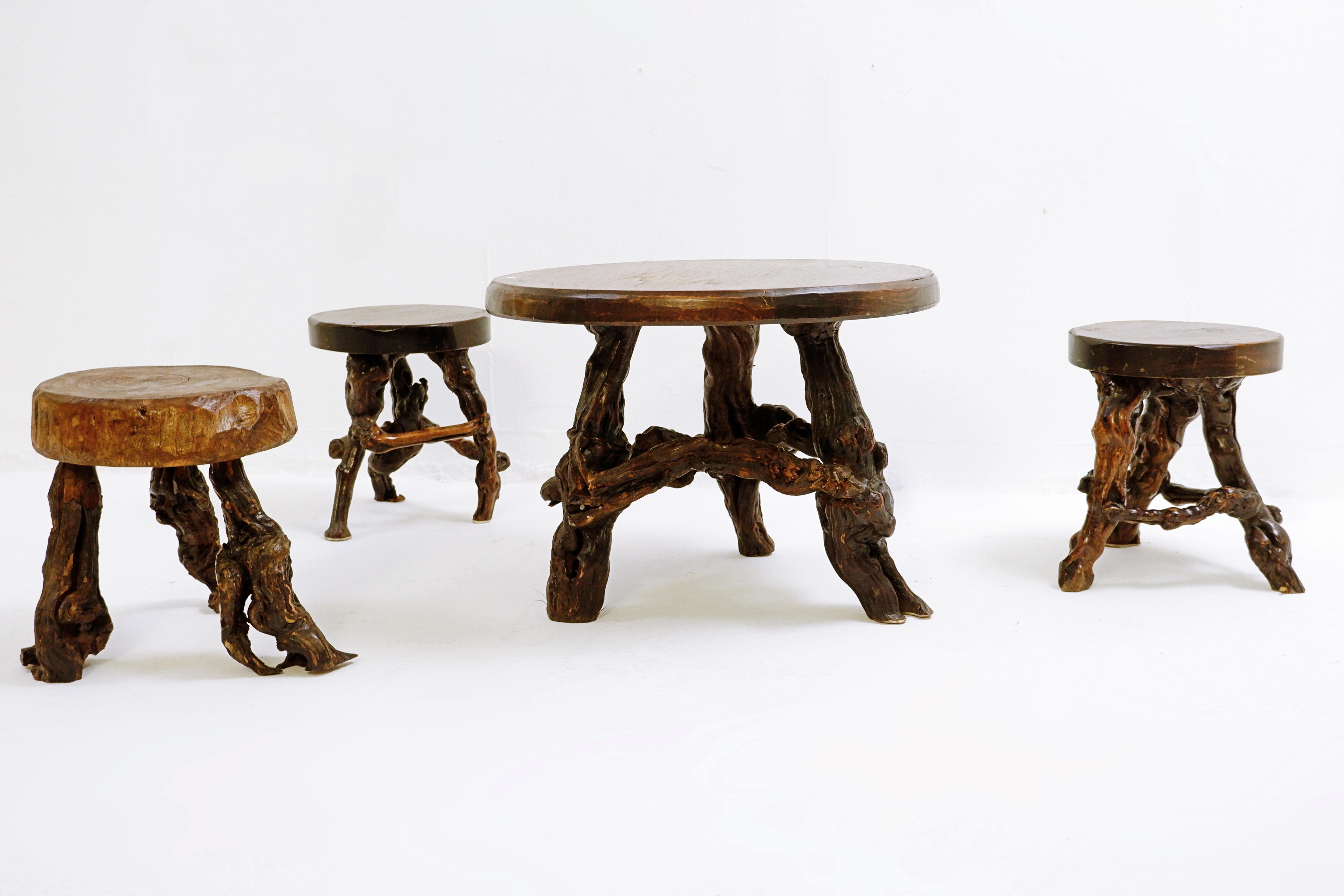 Primitive set table / stools with round slab seat and legs constructed from vines - set of 4 - circa 1960.