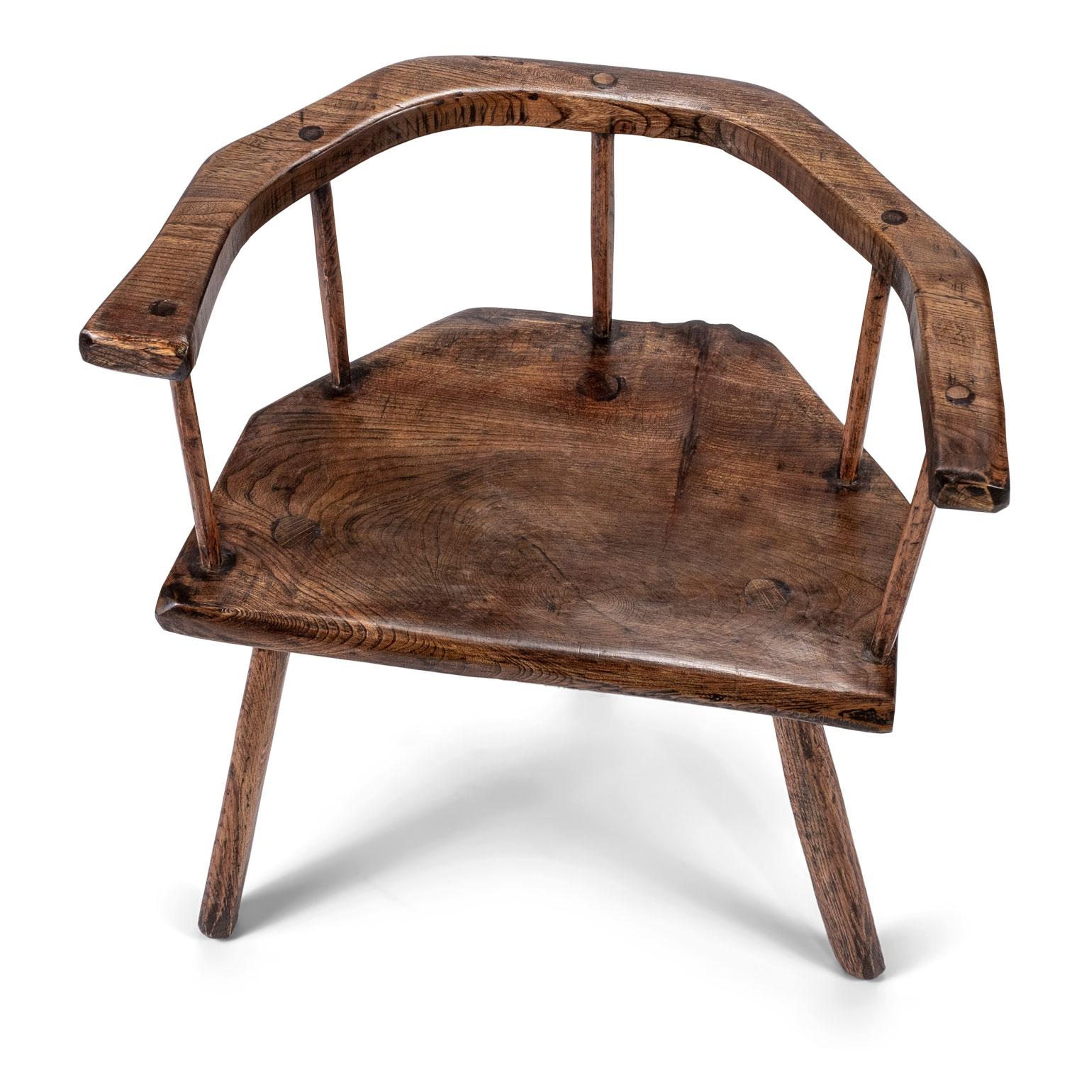 Primitive British stick chair hand-carved in elm and ashwoods. Carved elm horseshoe back rail and seat. Ash spindles and legs. Pegged construction. Gorgeous wood grain and patina. English in origin dating to the 19th century.