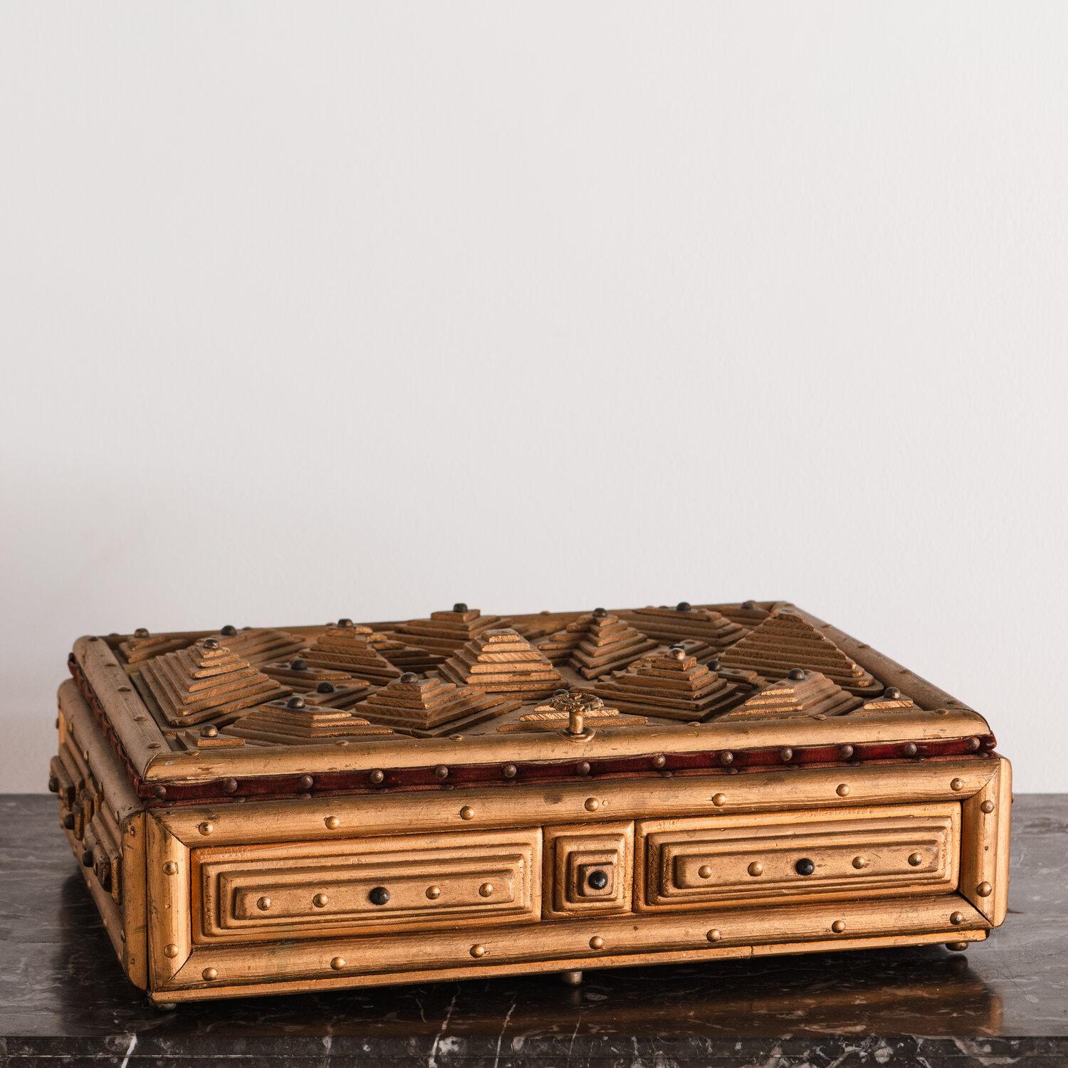 A stately vintage hand carved wood tramp lidded box, lined with red velvet. Tramp art refers a style of woodworking from the late 1800s known for its layers of geometric patterns.