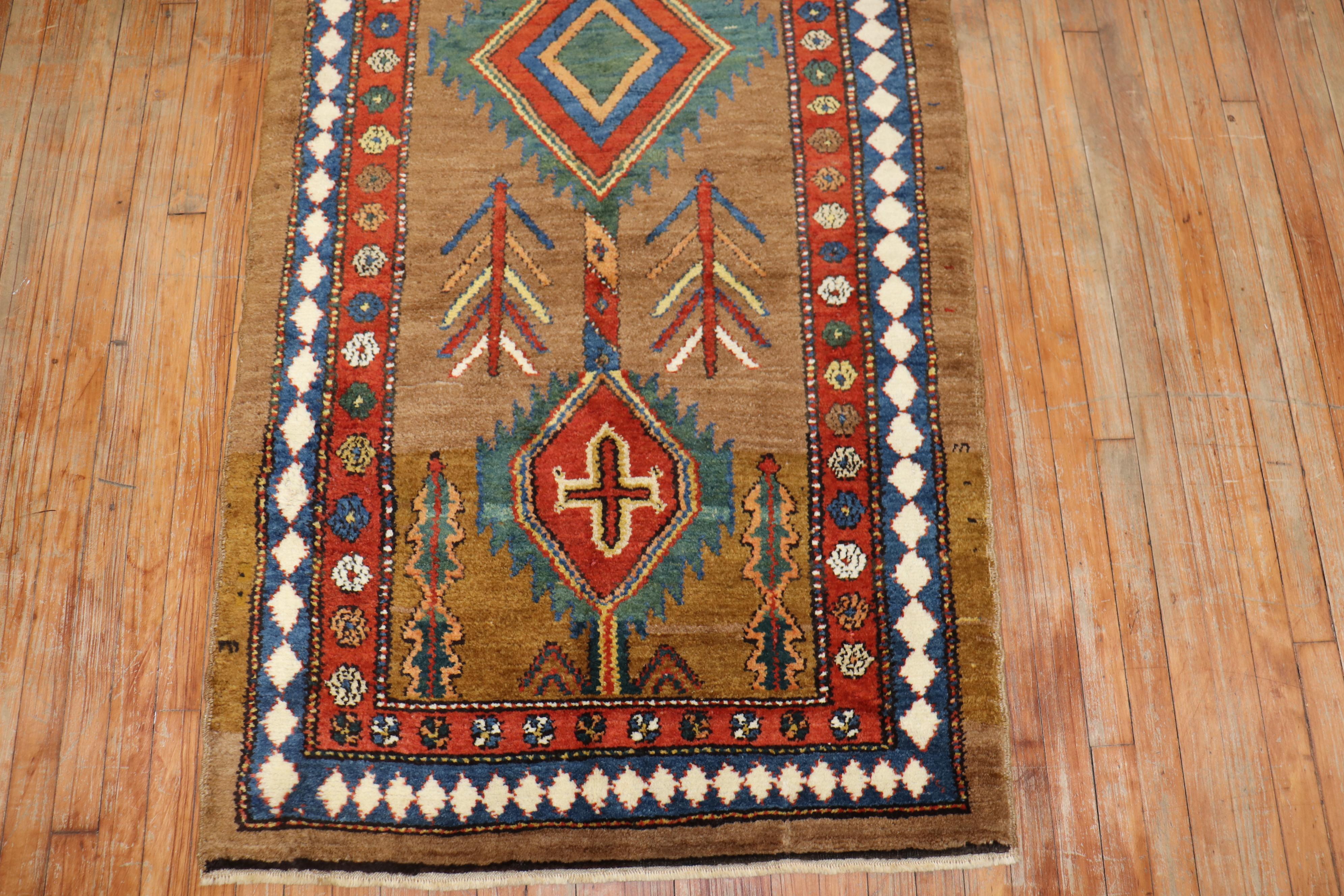 Highly collectible full pile Persian Serab runner with a camel color ground and bold geometric nomadi motif, circa 1920.

Measures: 3'5'' x 9' 

The best antique rugs and carpets utilizing un-dyed camelhair are quite rare, as they represent a