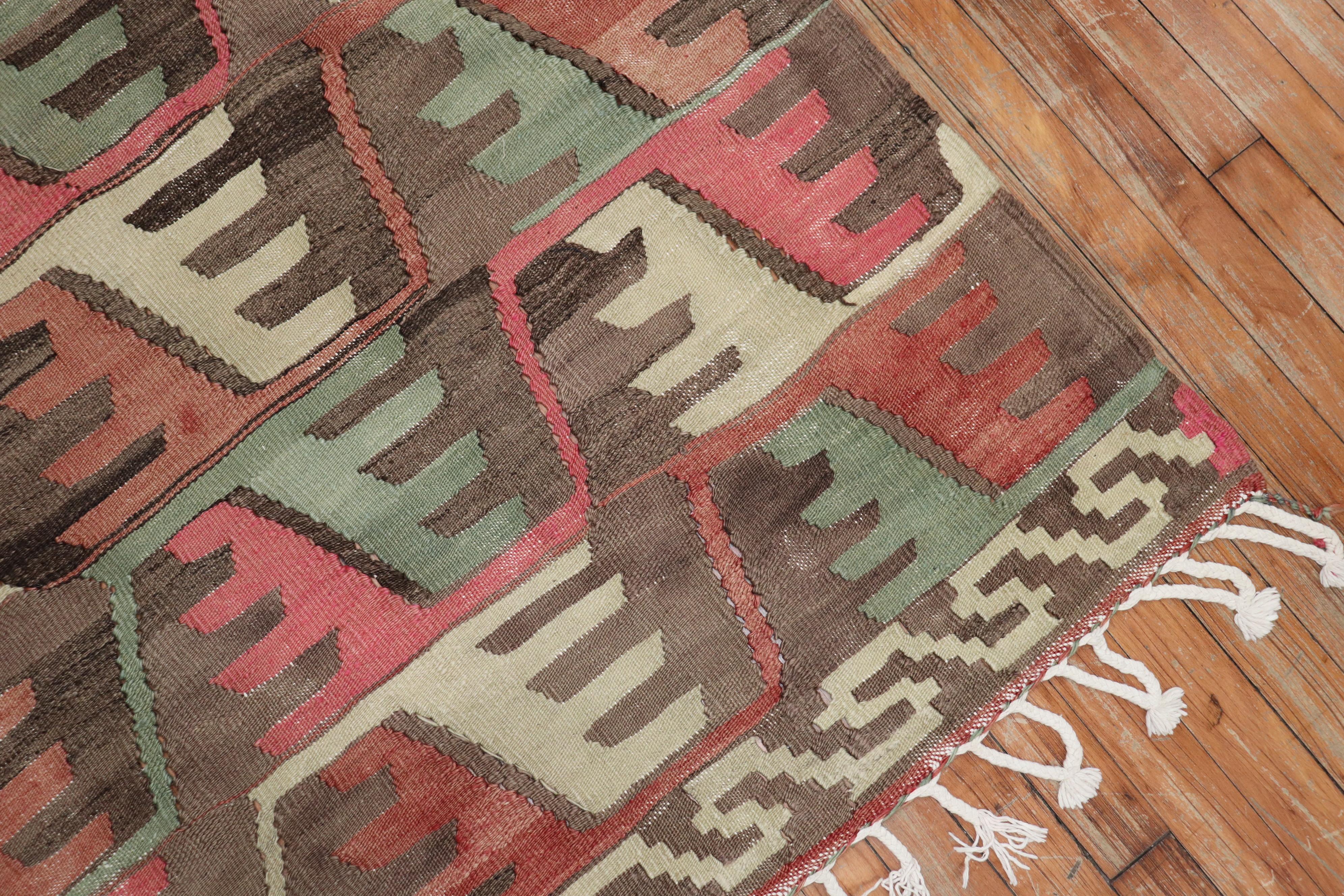 One of a kind, hand knotted Turkish tribal Kilim flat-weave from the second quarter of the 20th century with a rustic all-over geometric design predominantly in pink brown and green

Measures: 6'7