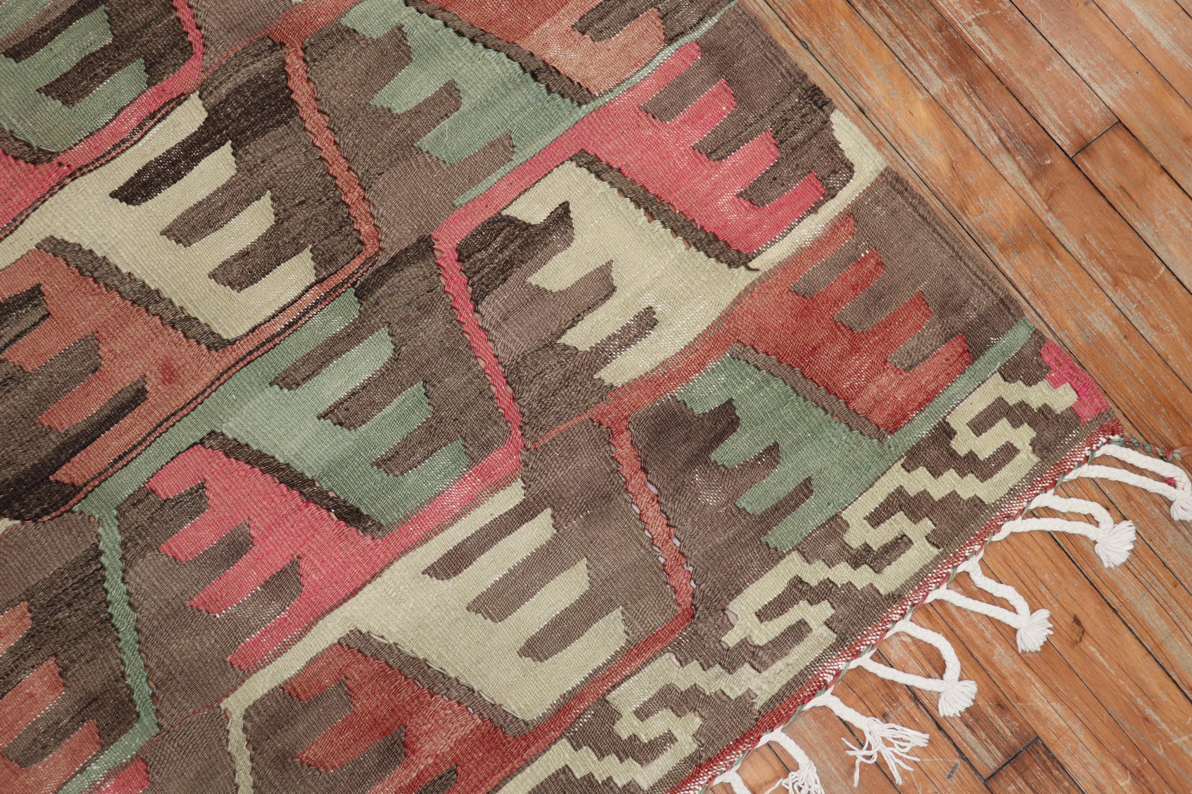 Tejido plano Kilim tribal turco anudado a mano, único en su género, del segundo cuarto del siglo XX, con un diseño geométrico rústico integral predominantemente en rosa, marrón y verde.

Medidas 6'7