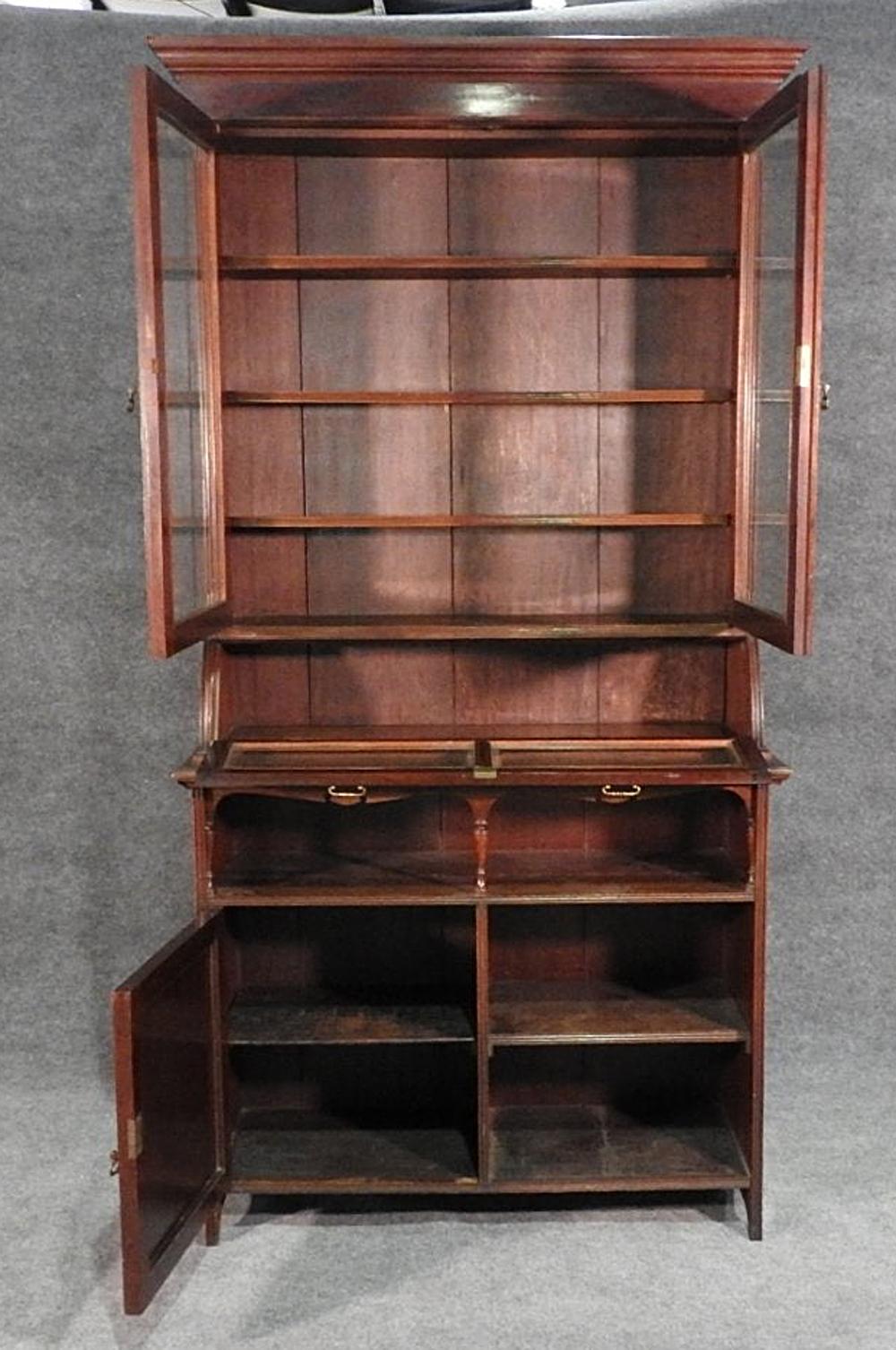 This is a unique antique English cupboard or china cabinet. With one lower door and one open shelf next to it, this piece is rather unique in its confirguration. The cabinet dates to the 1900-1910 era and is in its original patina and has signs of
