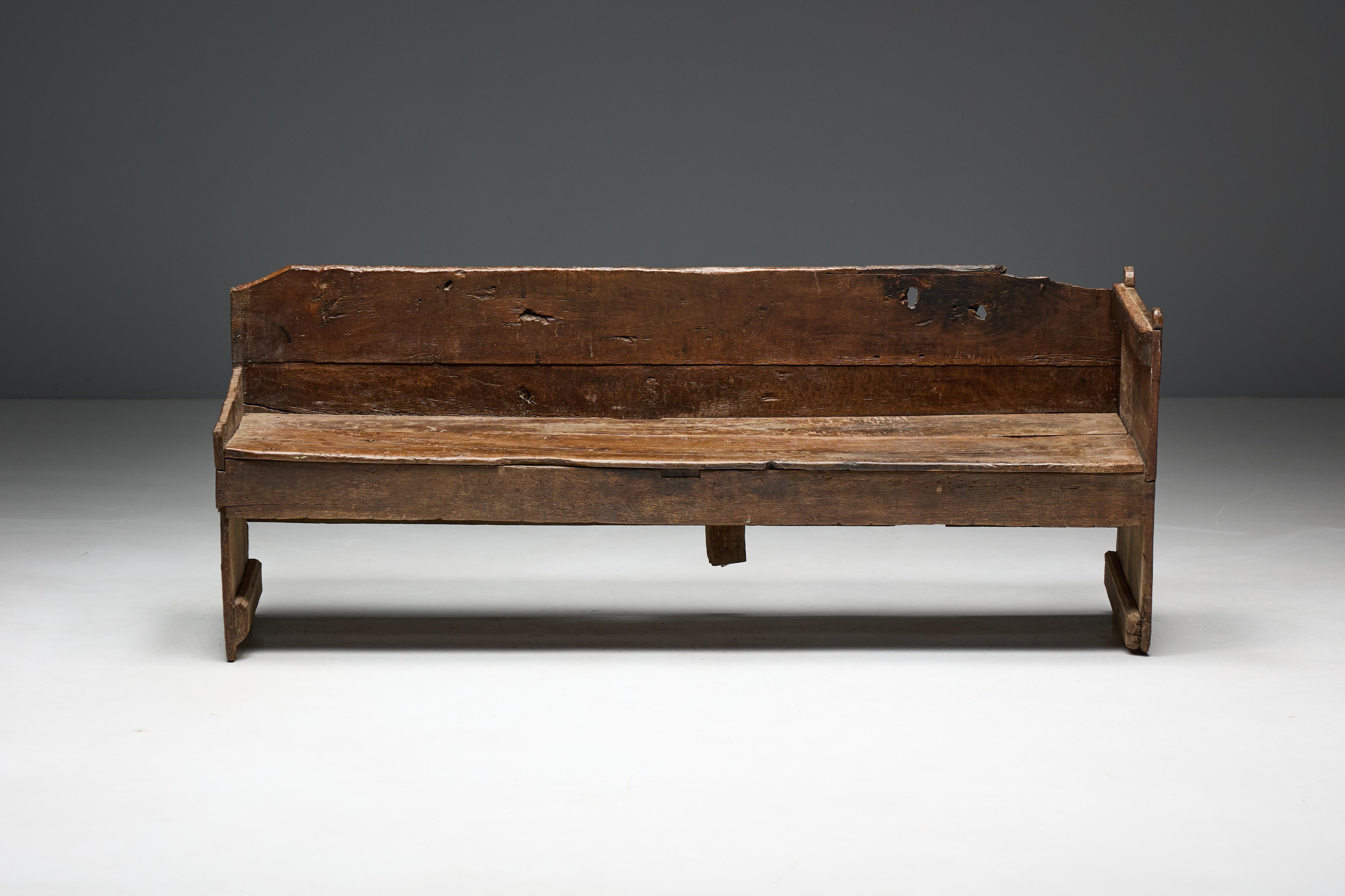 Banc rustique en bois qui incarne un charme brut et rustique qui parle de l'authenticité de l'art populaire et de la beauté de l'imperfection. Avec ses surfaces usées par les intempéries et sa construction simple, cette pièce met en évidence les