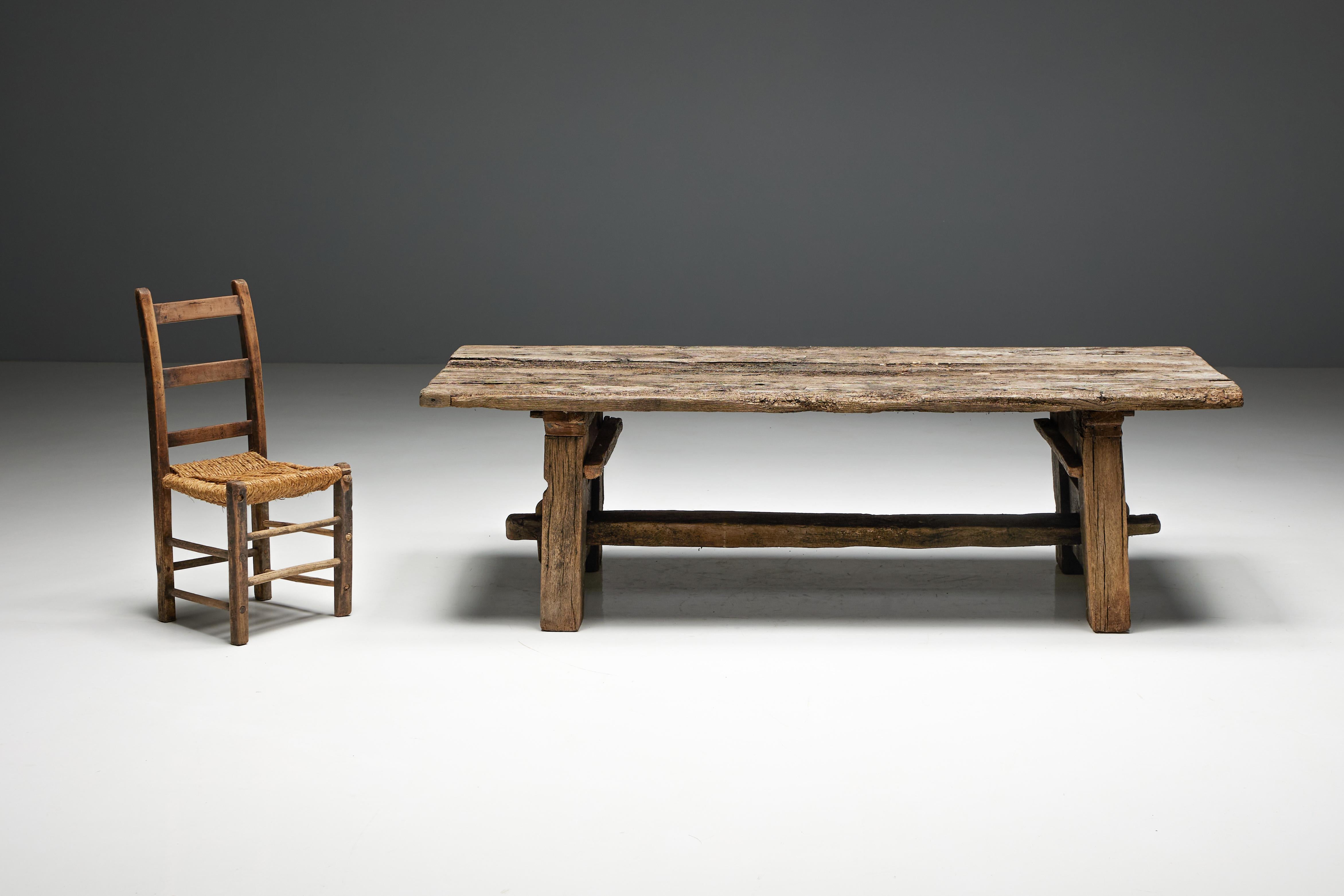 Table d'appoint rurale primitive du XIXe siècle, une pièce robuste et authentique fabriquée en bois massif brut. Sa surface met en valeur le grain naturel du bois, célébrant la beauté non raffinée de son époque. La construction robuste de la table