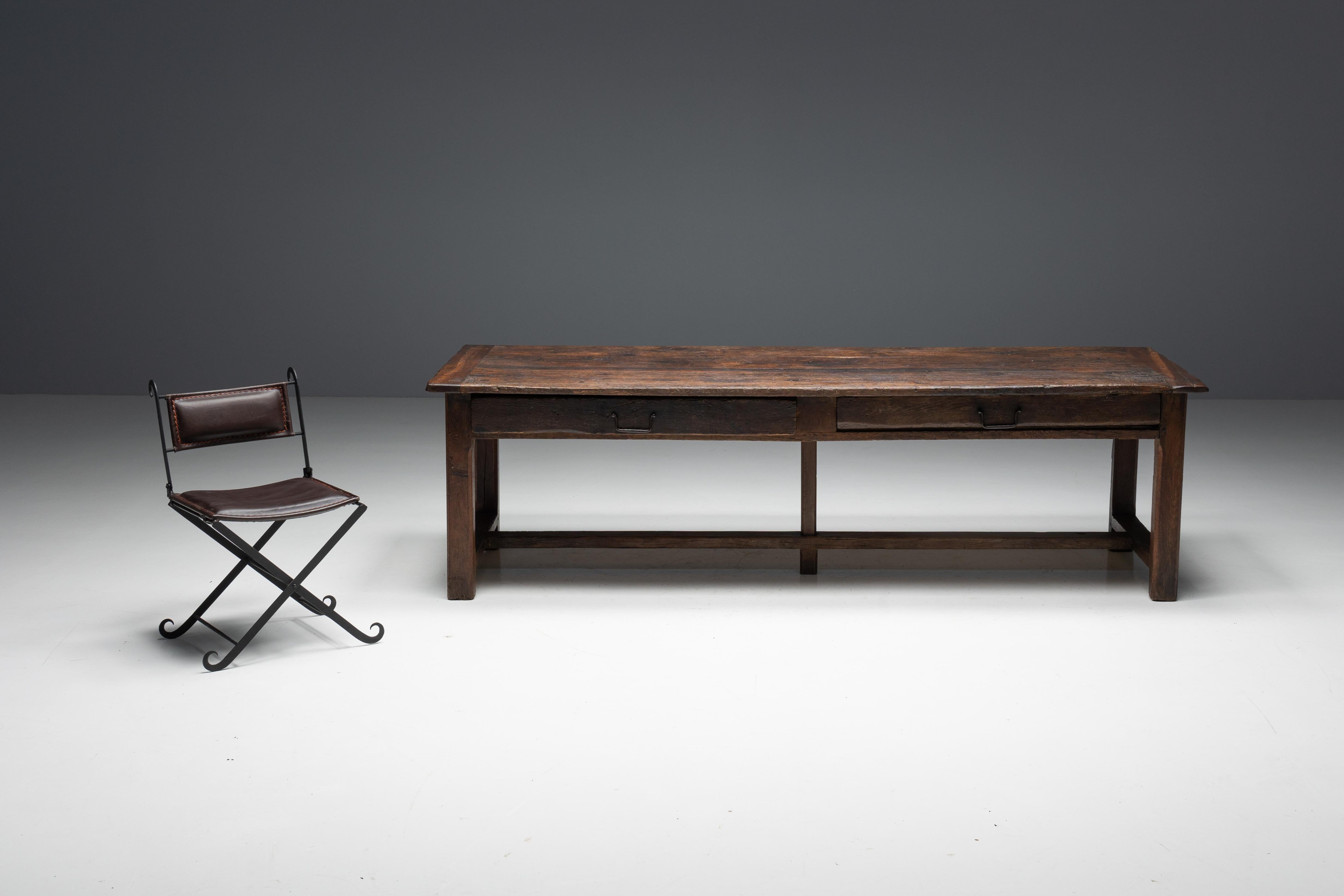 Originaire de France au XIXe siècle, cette table de ferme incarne le charme rustique avec sa patine naturelle attachante, qui s'est développée au fil des années d'utilisation. La table est fabriquée en bois brun foncé, ajoutant un sentiment de