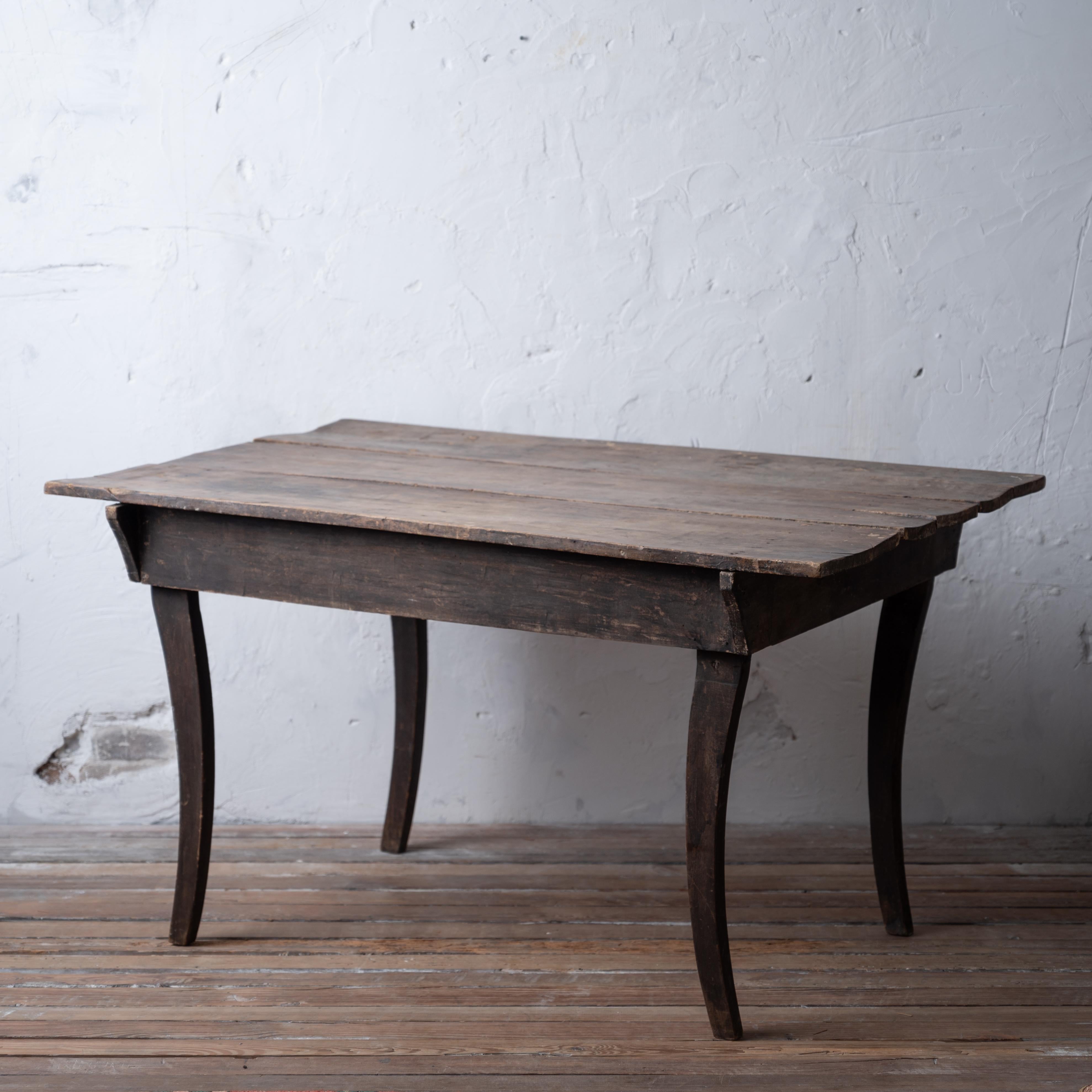 A primitive walnut sabre leg table with early black paint, 19th century.

54 inches wide by 24 ½ inches deep by 30 ¼ inches tall; 23 ¾ knee clearance. 

