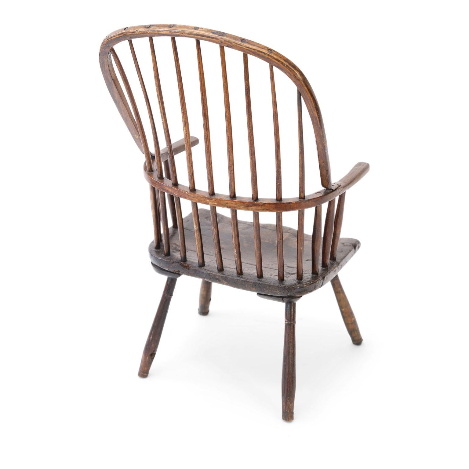 Primitive Windsor chair in yew and elm woods. Very sturdy with some restoration to arms. Constructed in a vernacular fashion circa 1770-1790 in the vicinity of Somerset, England.
