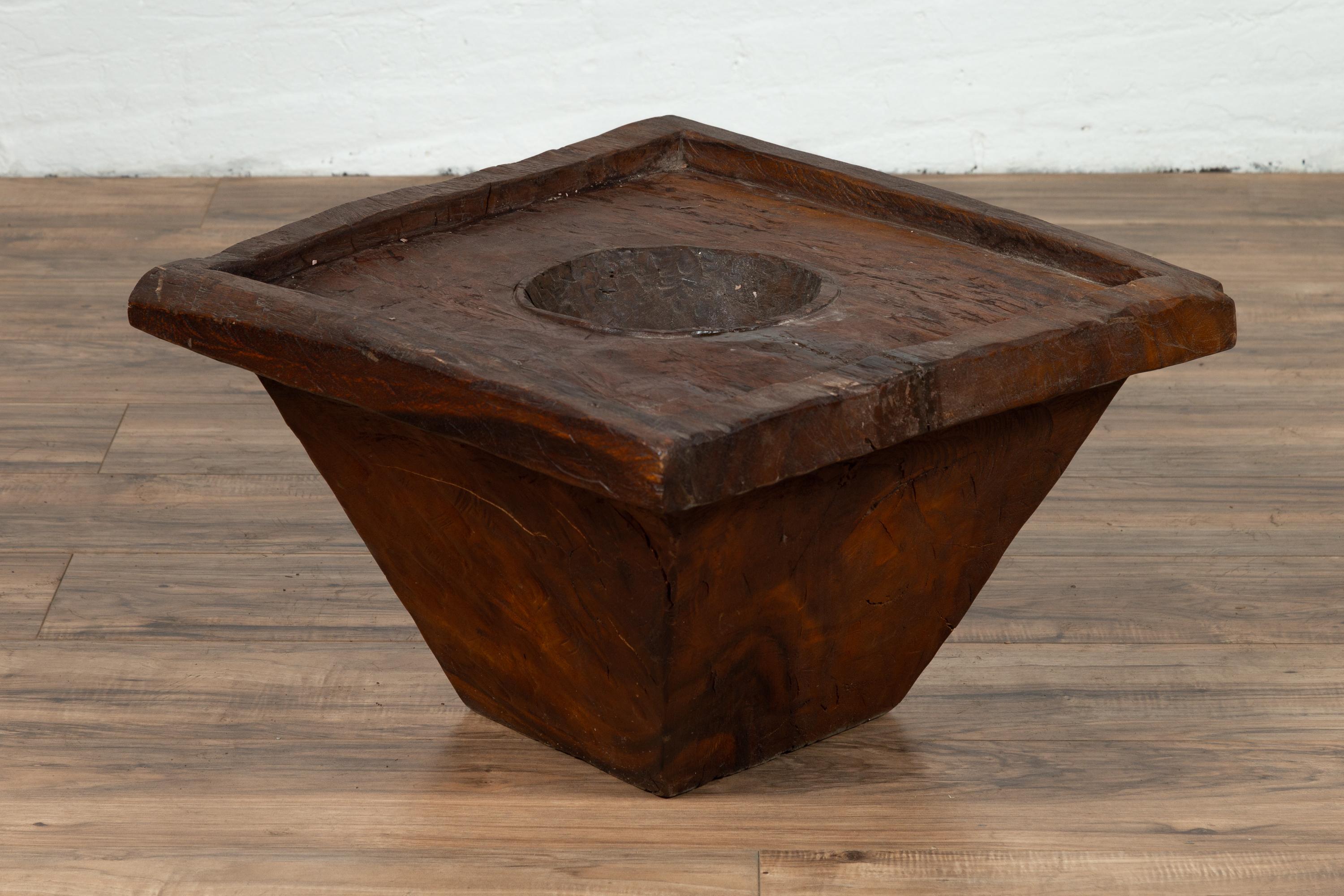 An antique wood Indonesian planter of rustic appearance from the early 20th century. Born in Indonesia and probably created to be a mortar used to store or grind up food, this wooden planter charms our eyes with its simple appearance and nicely