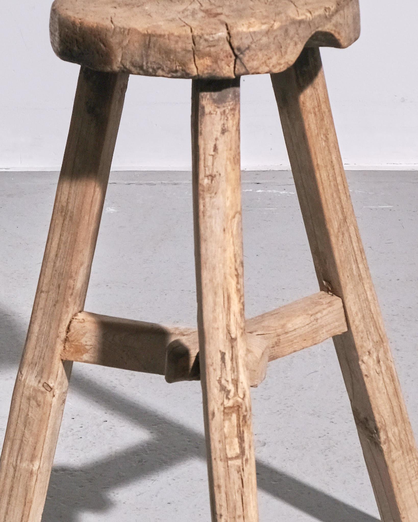 Un charmant tabouret primitif français en bois, datant des années 1940, avec un caractère merveilleusement honnête et rustique. Fabriquée en bois massif patiné par le temps, cette pièce reflète la simplicité et l'utilité du design rural français. Sa