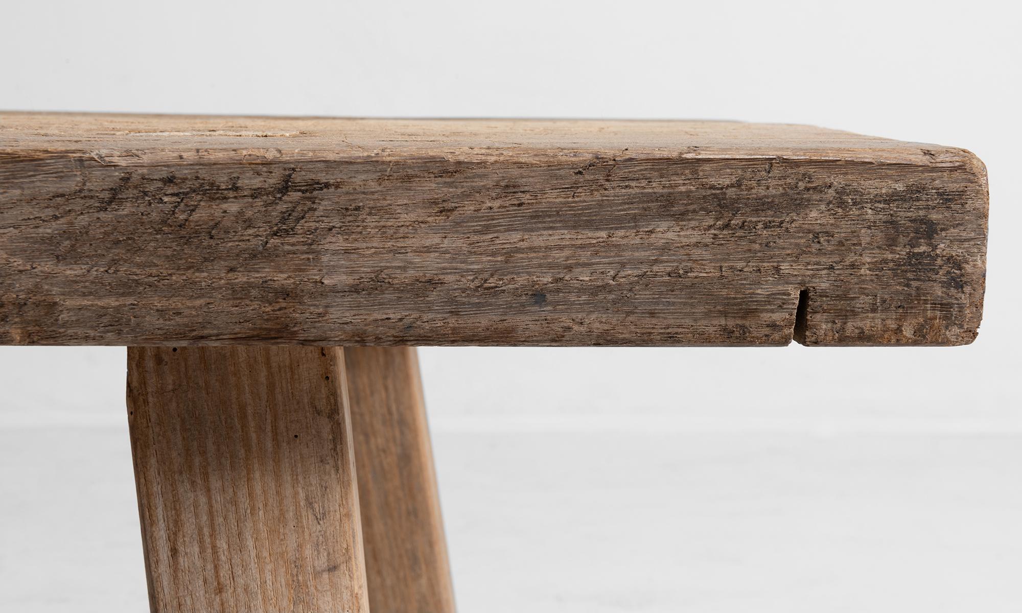 Pale, scrubbed oak bench with thick top on splayed legs.
  