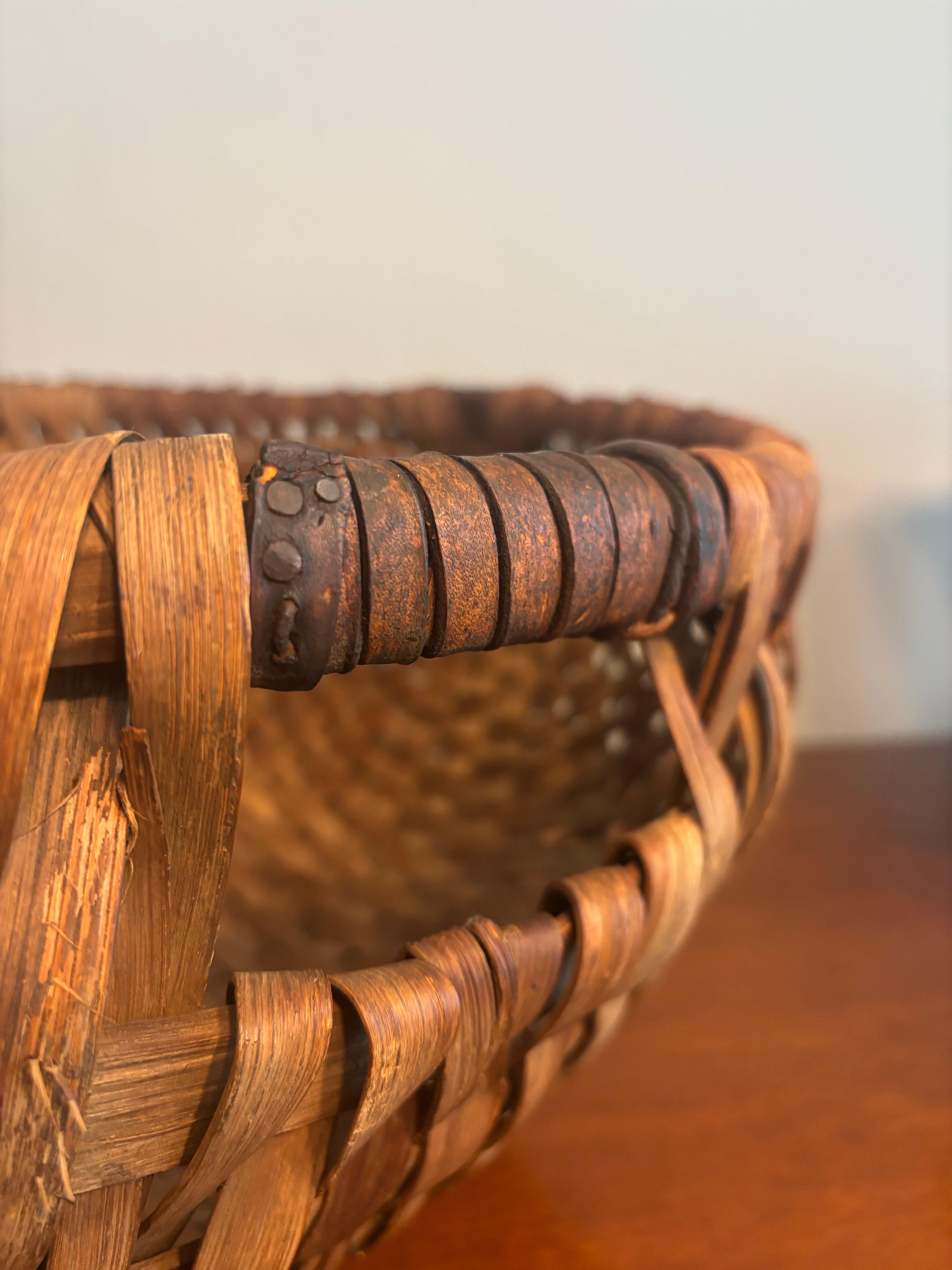 Exemple frappant de l'artisanat utilitaire primitif élevé au rang de forme d'art sculpturale, ce grand bol primitif en bois fendu tressé respire la présence et l'authenticité. D'une largeur impressionnante de 21,5 pouces, d'une profondeur de 20,5