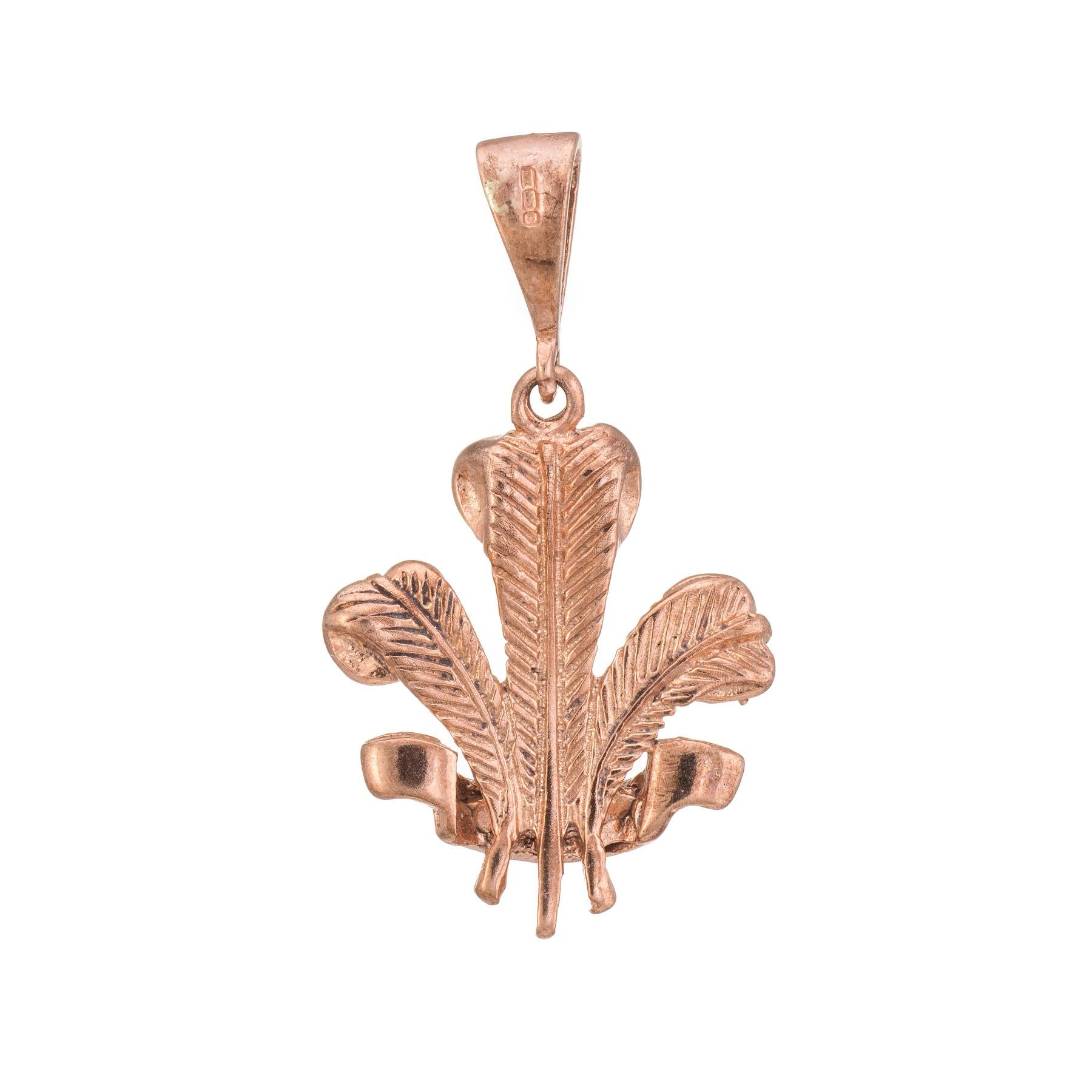 Finely detailed Prince of Wales feathers charm, crafted in 9 karat rose gold.

The Prince of Wales feathers is the heraldic badge of the Prince of Wales. It consist of three white ostrich feathers. A ribbon below the coronet bears the motto Ich Dien
