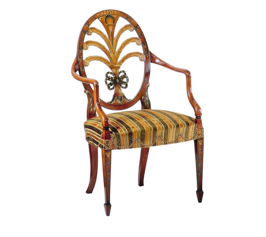 A triumph of ornate hand-painted details lends this beechwood chair its eccentric decorative charm. A fine reproduction of a Prince of Wales original (1800-1820), it features sinuous and sloping armrests extending from an oval backrest whose