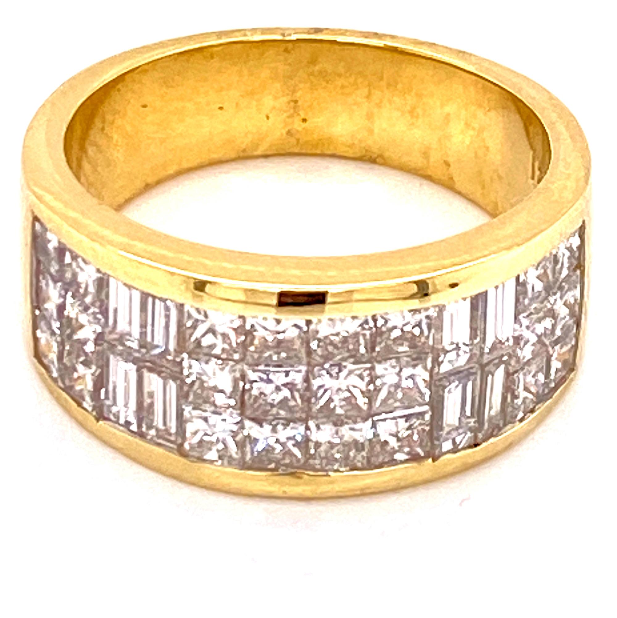 Fabulous diamond band ring fashioned in 18 karat yellow gold. The ring is invisibly set with sparkling princess and baguette cut diamonds weighing 2.26 carat total weight. The diamonds are graded G-H color and VS clarity. The band measures 9mm in