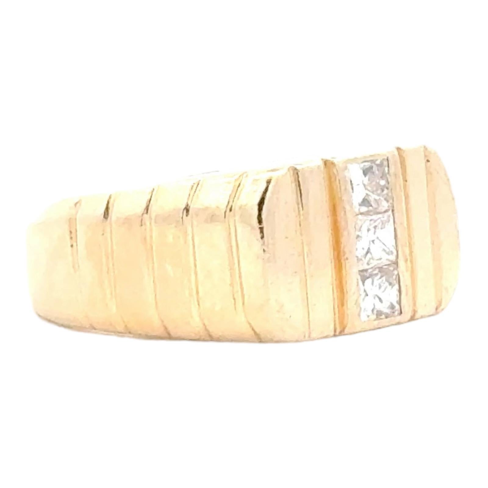 Three diamond band ring fashioned in 14 karat yellow gold. The ring features 3 princess cut diamonds weighing approximately .50 carat total weight and graded G-H color and VS clarity. The band measures 5-9mm in width and is size 7 (can be sized).