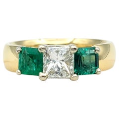 Anillo de oro amarillo de 18 quilates con tres piedras, diamante talla princesa y esmeralda