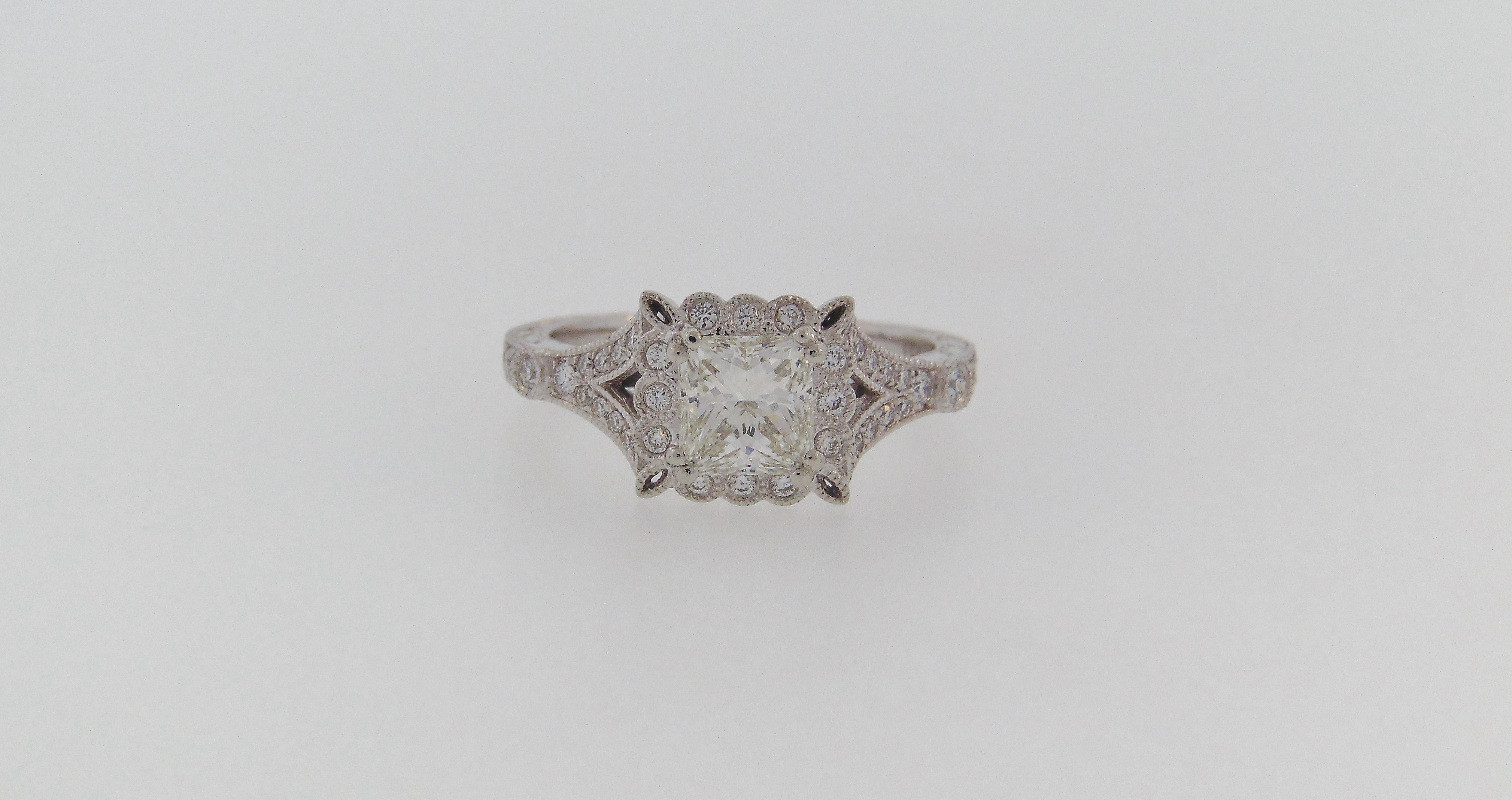 Designed by Amavida, intricately detailed vintage reproduction platinum mounting.  The ring is centered by one (1) princess cut diamond weighing 1.02 carats, graded GIA SI1 clarity, I color.  The mounting is further accented with a beaded edge and