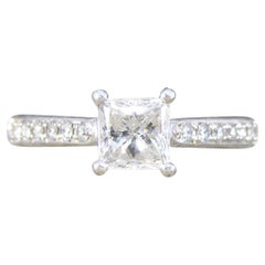 Verlobungsring mit Diamant im Prinzessinnenschliff und diamantbesetzten Schultern aus Platin mit Diamantbesatz