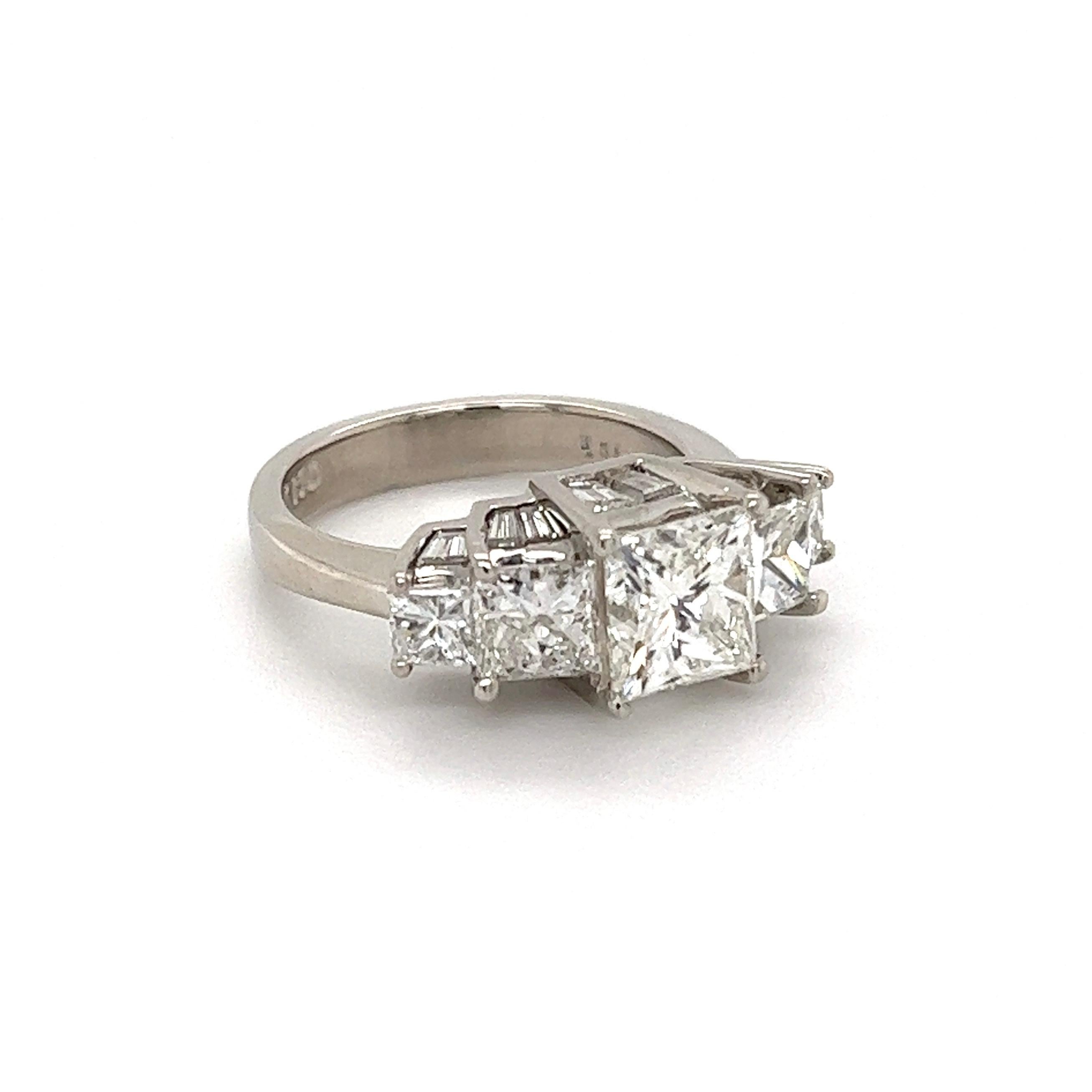 Simply Beautiful! Finely crafted Five Stone Princess-cut Quad Diamond Ring. Centering an amazing Hand set securely nestled Princess-cut Diamond weighing approx. 1.52 Carat with 2 quad cut Princess cut diamonds Diamond on either side, weighing