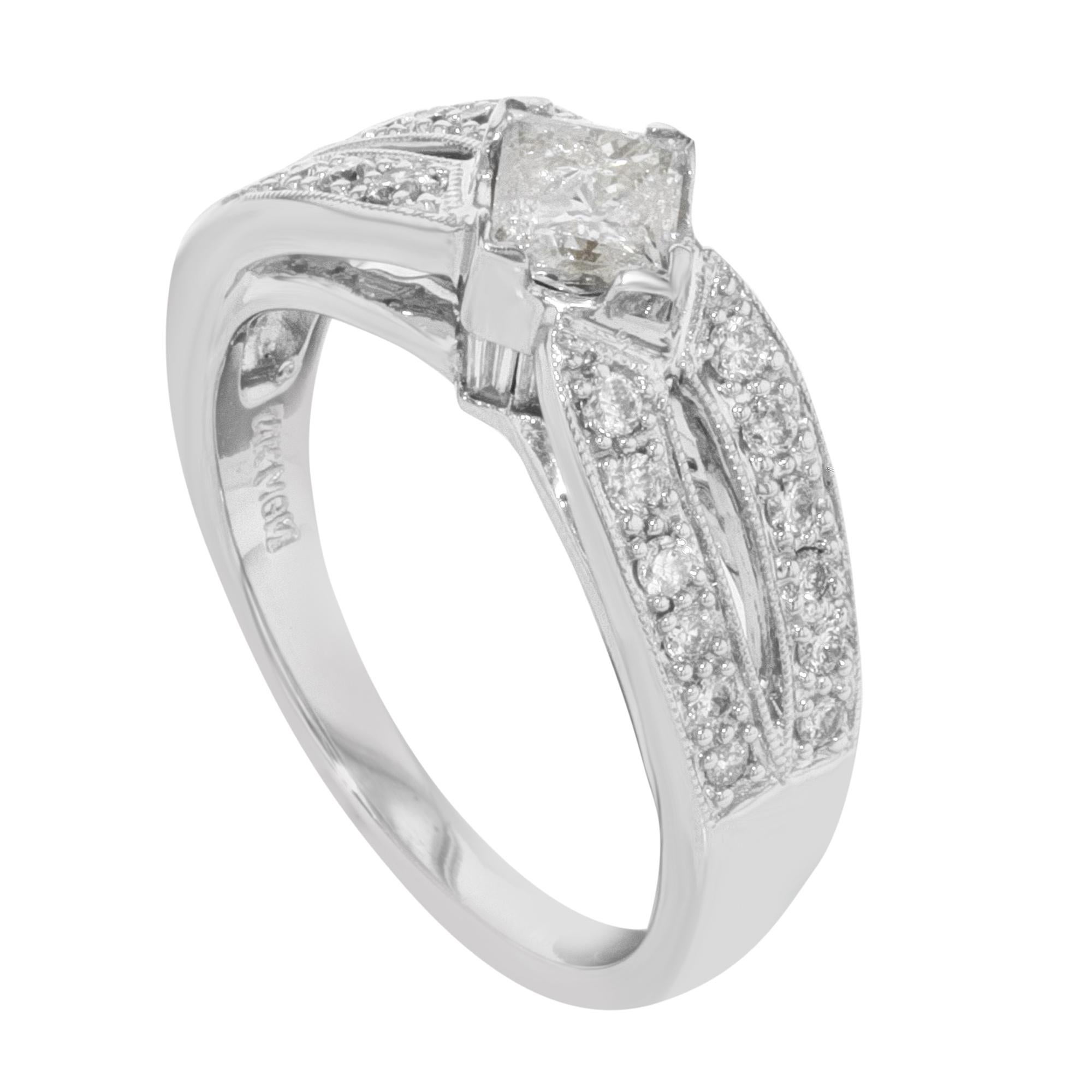 This beautiful diamond engagement ring is crafted in 14k white gold. It features a center princess cut diamond weighing approx. 0.62ct accented with 24 round cut diamonds weighing approx. 0.63ct. Total diamond weight: 1.25 carats. Ring size 7.5.
