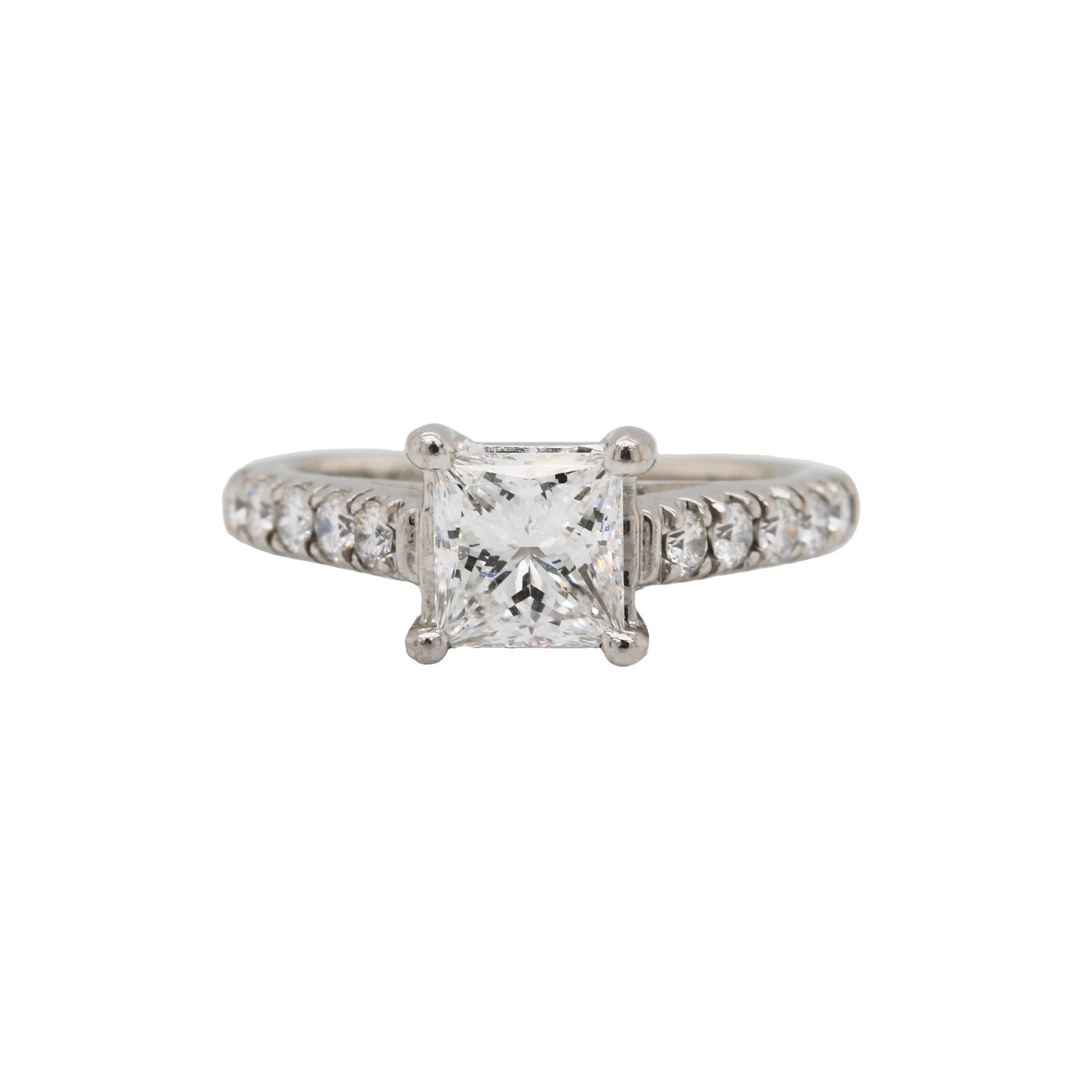 This elegant estate ring features a 1.07ct G - VVS2 center princess cut diamond in a four prong setting in gleaming platinum. This ring is accented with round brilliant diamonds along the band for extra glamour. This piece comes with a GIA