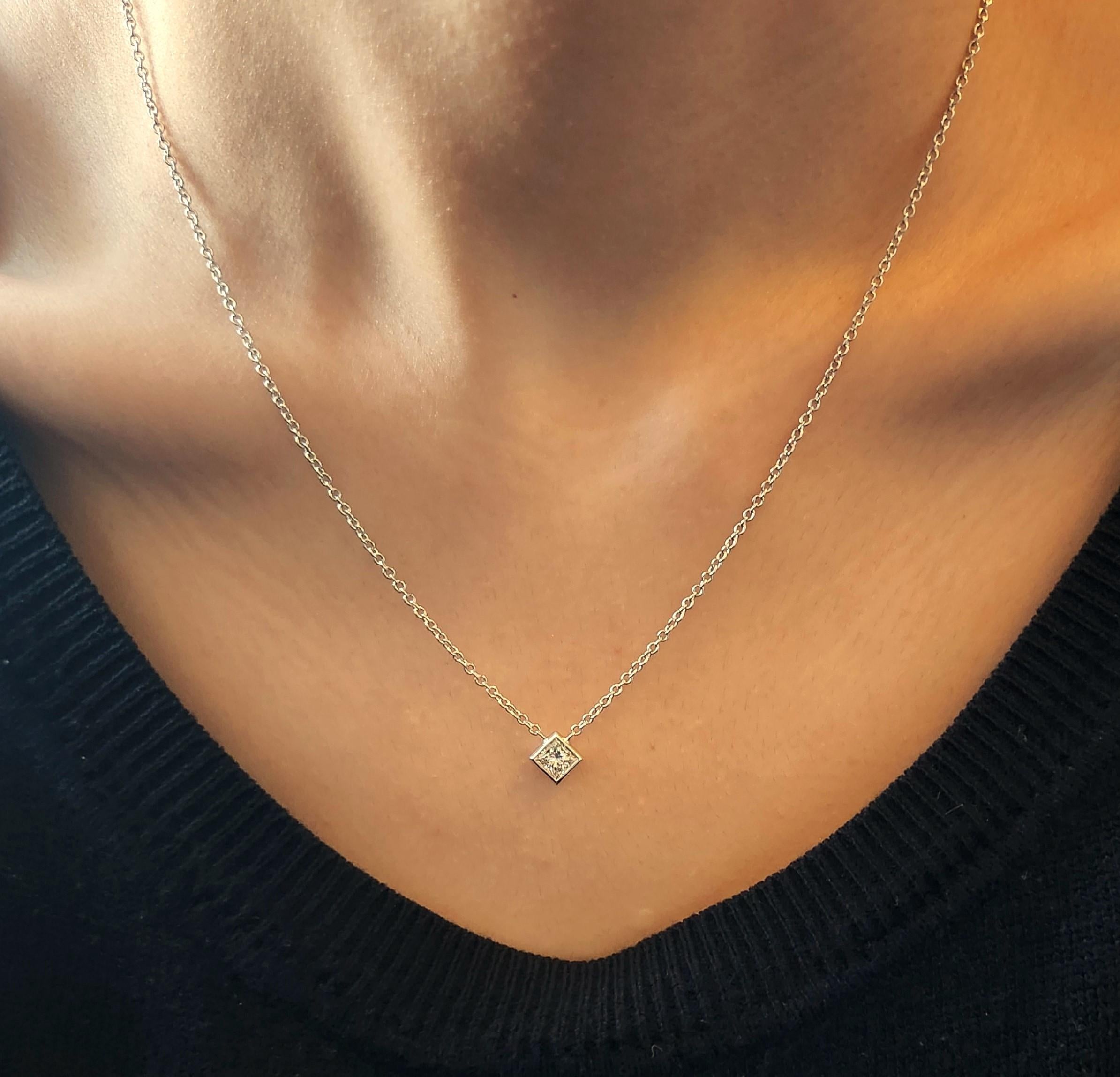 14K White Gold handmade bezel setting with a beautiful .72CT white Princess cut diamond. The heavy bezel is permanently attached to the 14K white gold cable chain and a Lobster clasp. The chain has a loop at 18