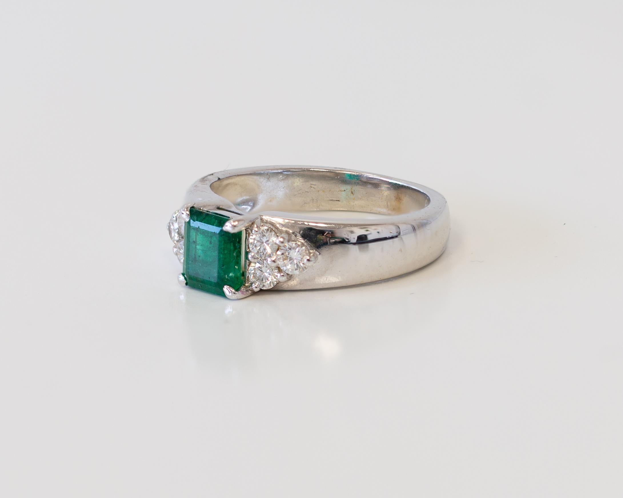 Ring aus 18 Karat Weißgold mit Smaragd im Prinzessinnenschliff in der Mitte und seitlichen Diamanten (Carréschliff) im Angebot