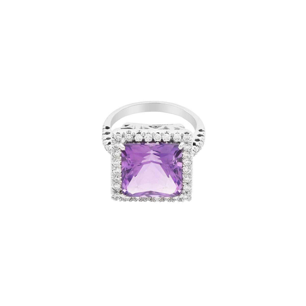 This fairy-tale-inspired ring features a princess-cut amethyst with a diamond halo. It is centered on an 18 Kt white gold, diamond-pavé shank. 
The ring features a sizable amethyst surrounded by diamonds, which are also placed along the shoulder.