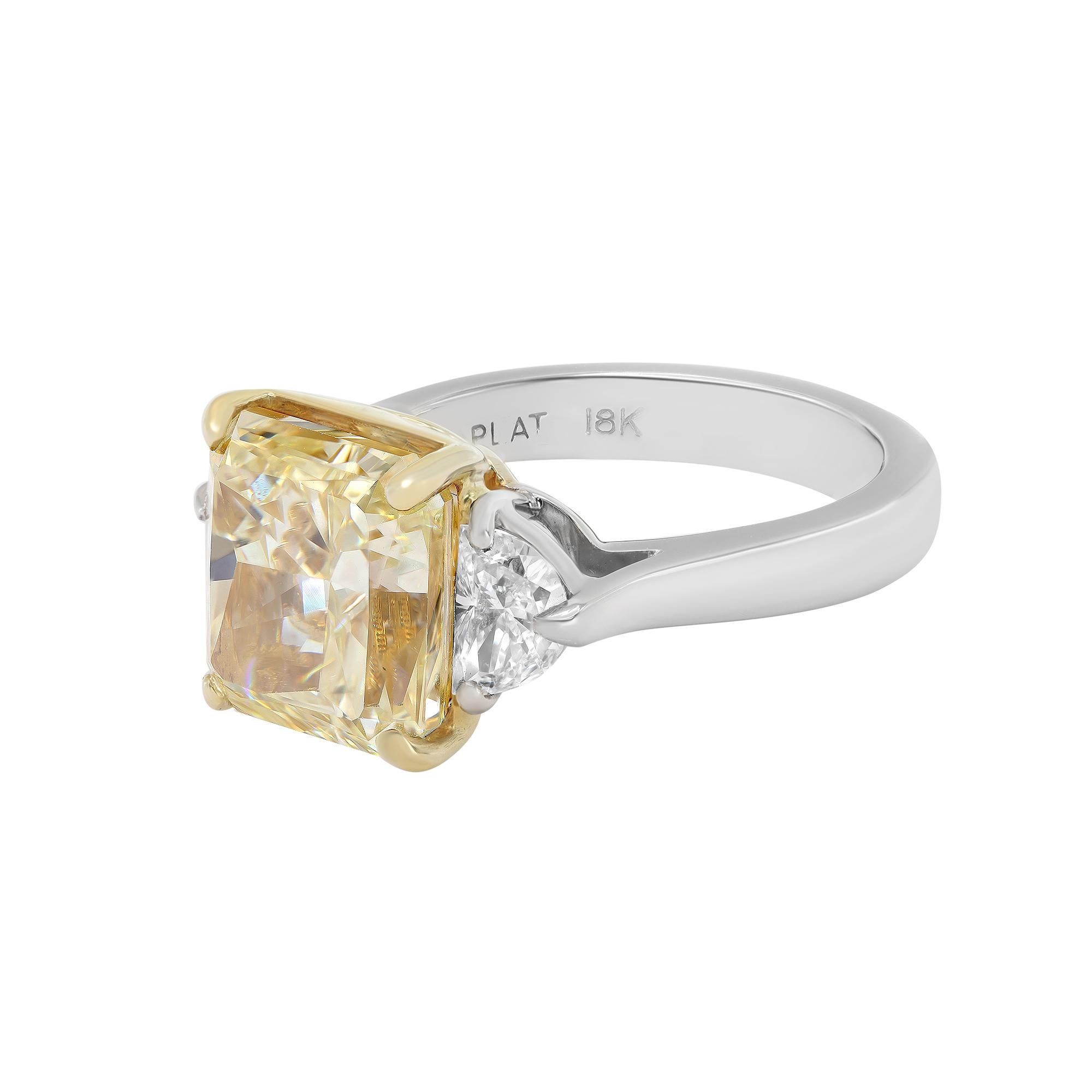 With a strong and stunning array of femininity and vibrant hues, this rare handmade three stone, fancy light yellow diamond ring is a remarkable addition to your jewelry collection. Crafted in platinum and the center stone shank in 18K yellow gold.