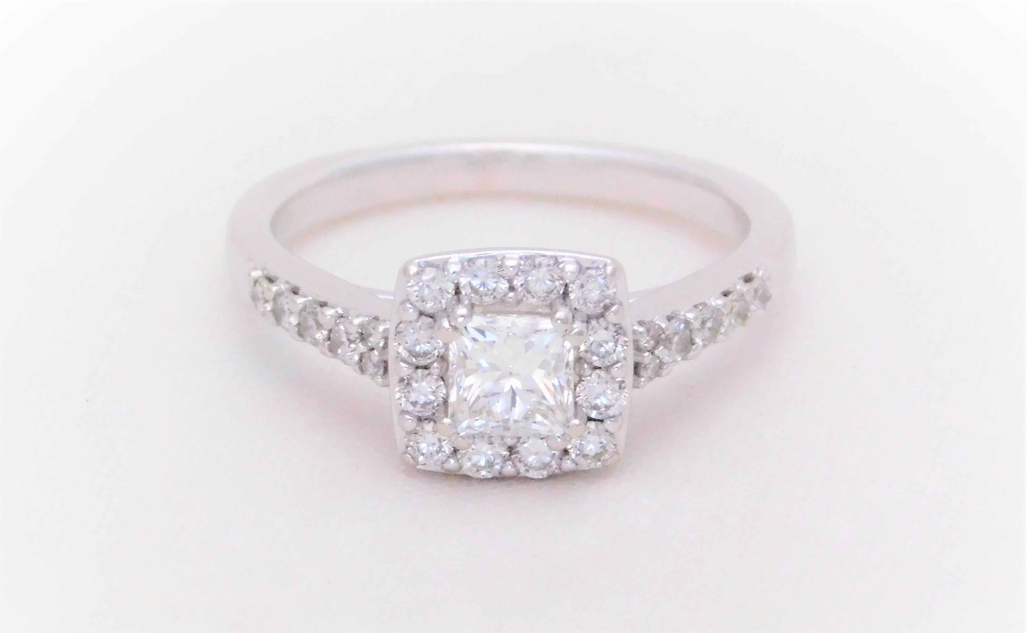 Bright and sparkling!  This charming halo-style engagement ring has been masterfully crafted in solid 14k white gold.  It has been jeweled with a 0.46ct natural princess-cut diamond as its dazzling center stone.  This very high-quality diamond has
