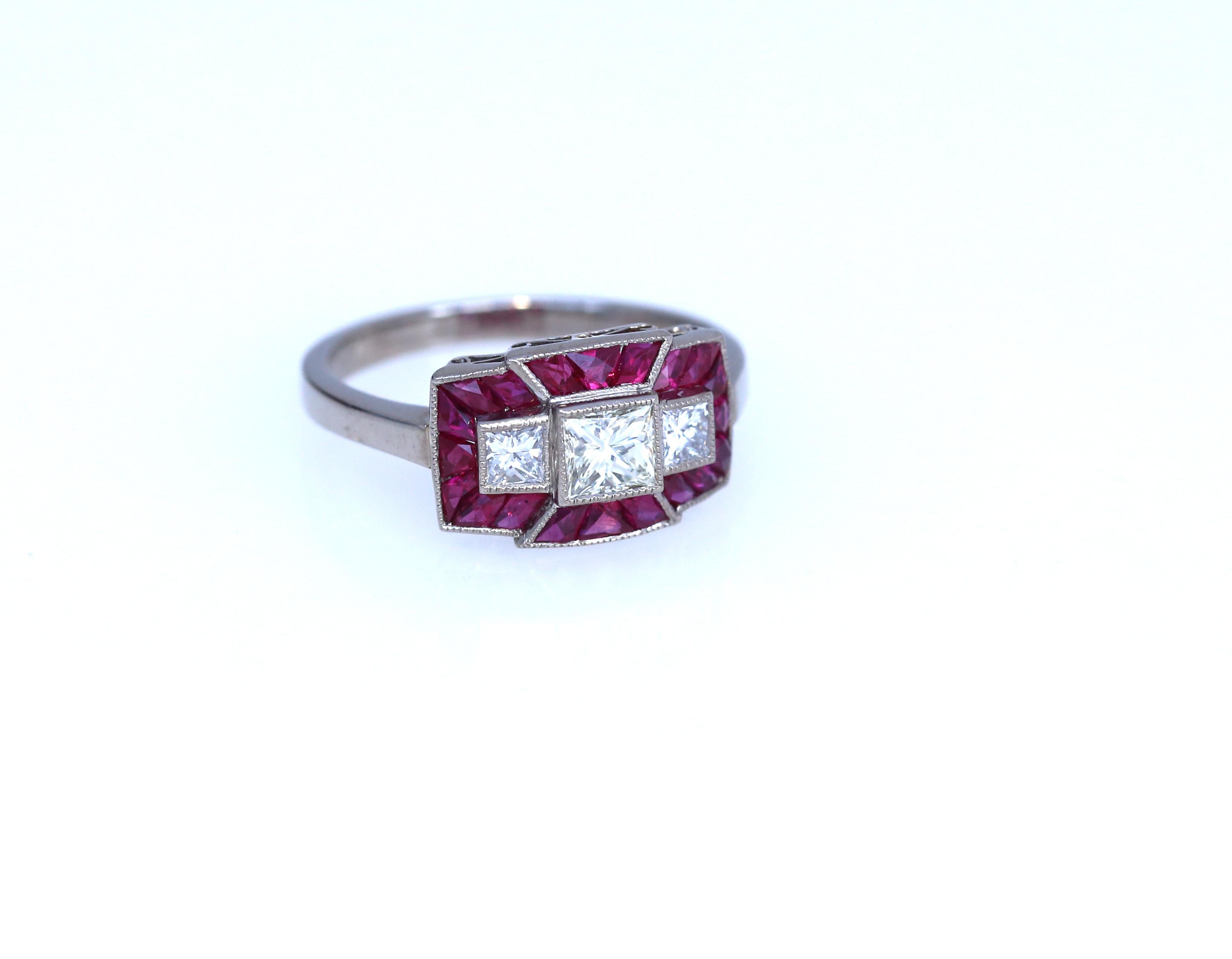 Delicate White Gold 18K ring with three Princess cut Diamonds surrounded by the special cut Rubies of fine deep red color. 1960. Elegant ring. Stamped 18K.
Total approximate weight of the Rubies is 1.2 Ct
Center princess cut Diamond approximate