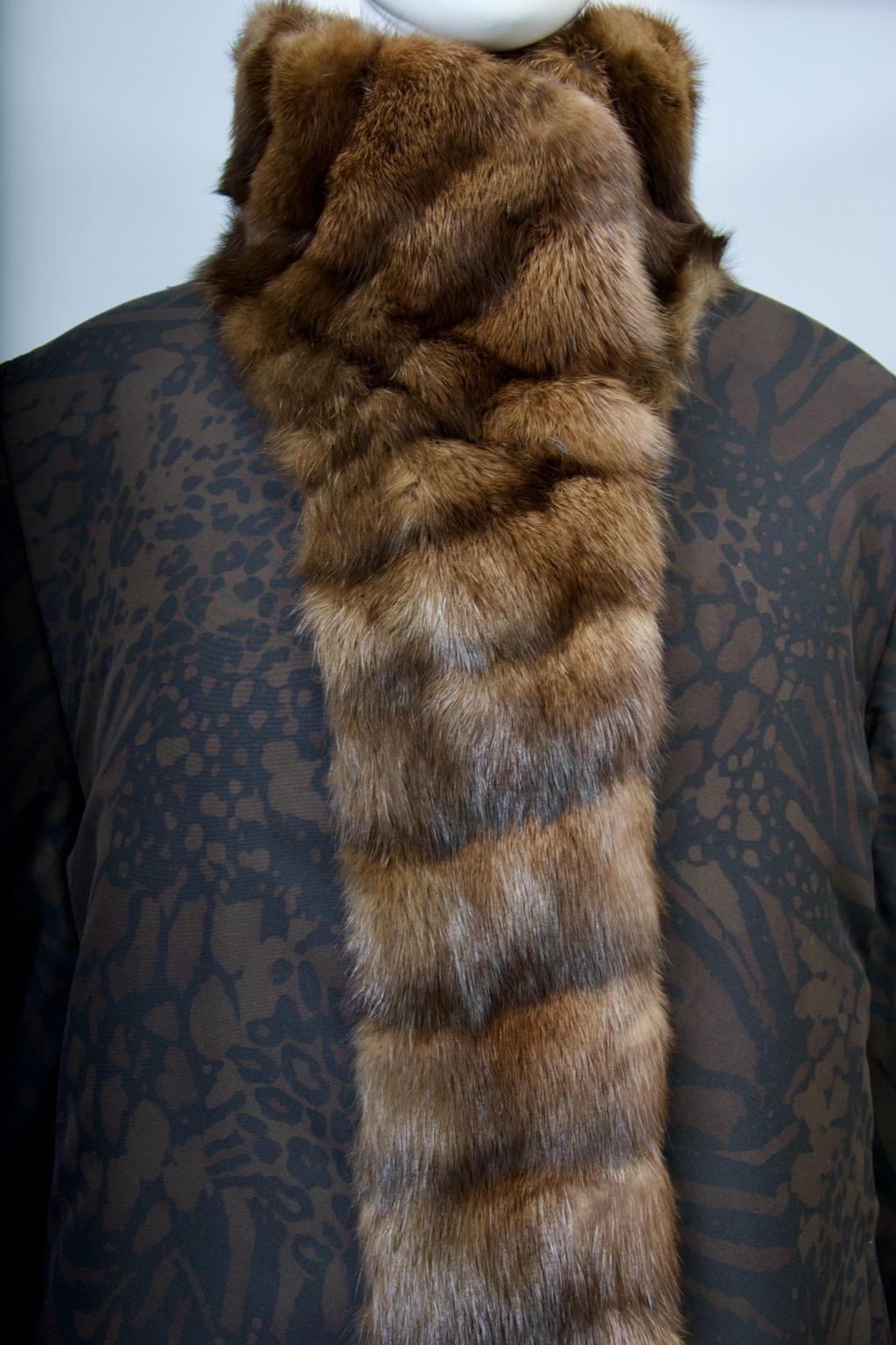Un abrigo doble único, la pieza principal de sedoso estampado negro y marrón con un cuello de marta que continúa por la parte delantera del abrigo hasta el dobladillo. Está forrado con la misma tela y entre medias hay una entretela esponjosa para