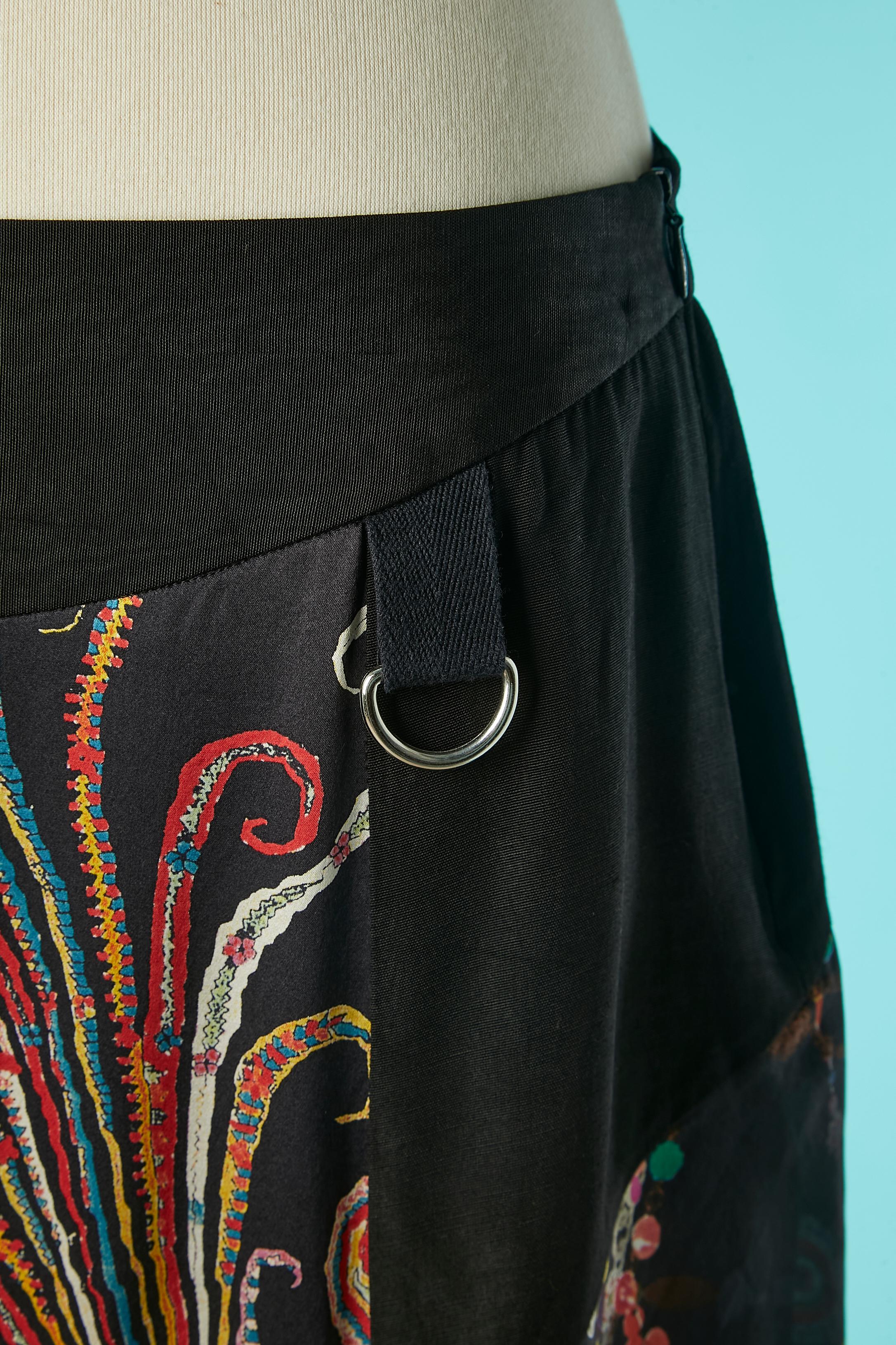 Gonna stampata e plissettata con lavorazione a taglio. Tessuto principale (fianchi e vita): 57% rayon, 43% acetato. Tessuto stampato: seta. Tessuto plissettato: seta. Zip sul lato sinistro.
TAGLIA: 42 (Fr) L. 