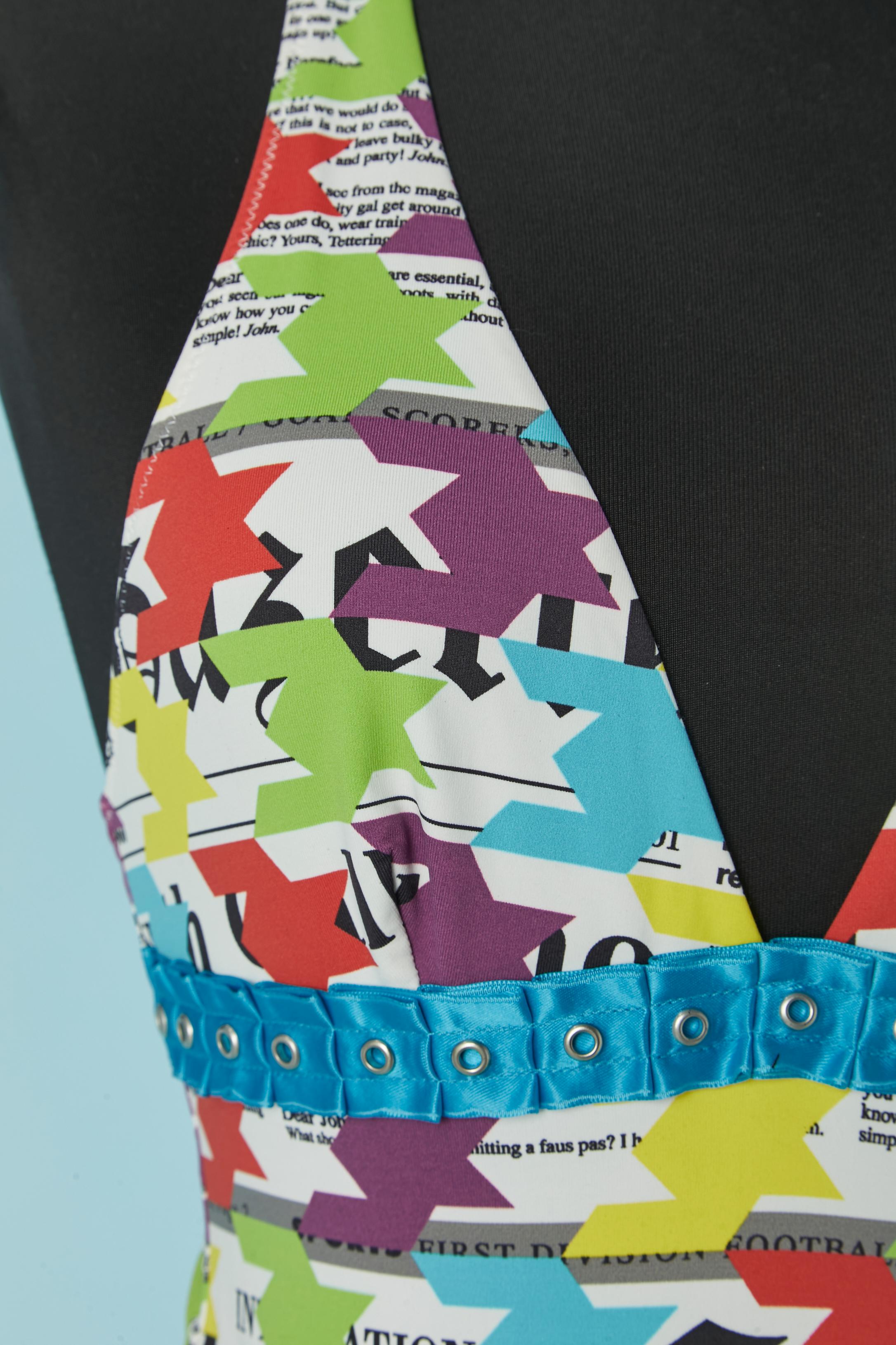 Bedruckter rückenfreier Badeanzug mit blauem Rüschenband mit Öse unter der Brust. 
Zusammensetzung des Stoffes: 80% Nylon, 20% Elastan. Verschluss mit Markenzeichen auf der hinteren Mitte. Echtheitshologramm. 
GRÖSSE S (US) M ( Eu) 