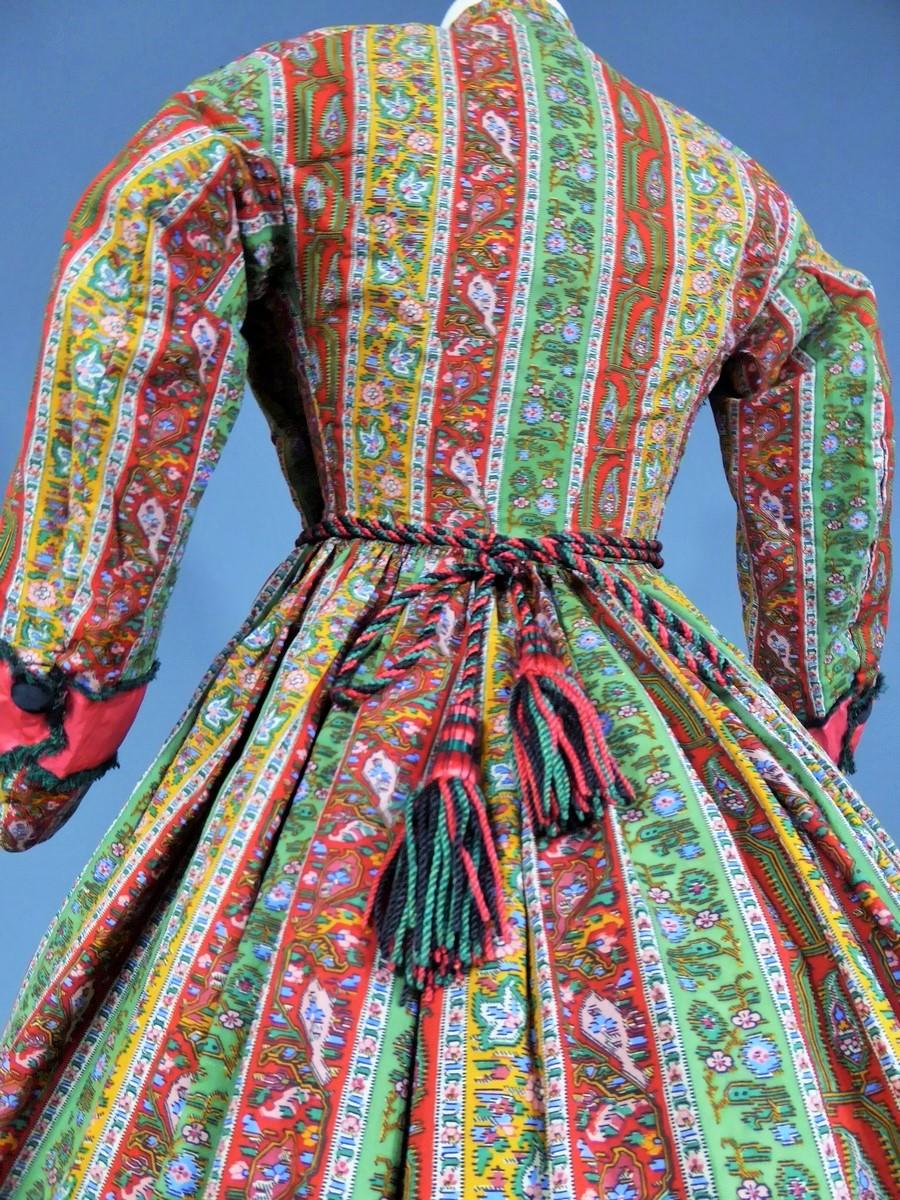 Circa 1860
Europe
Beautiful dress with crinoline walk or indoor printed bunting bayadère dating from the French Second Empire. Fine print on roll or Alsatian from English wool (?) . Wide strips of cherry red satin -lined emerald frayed in the