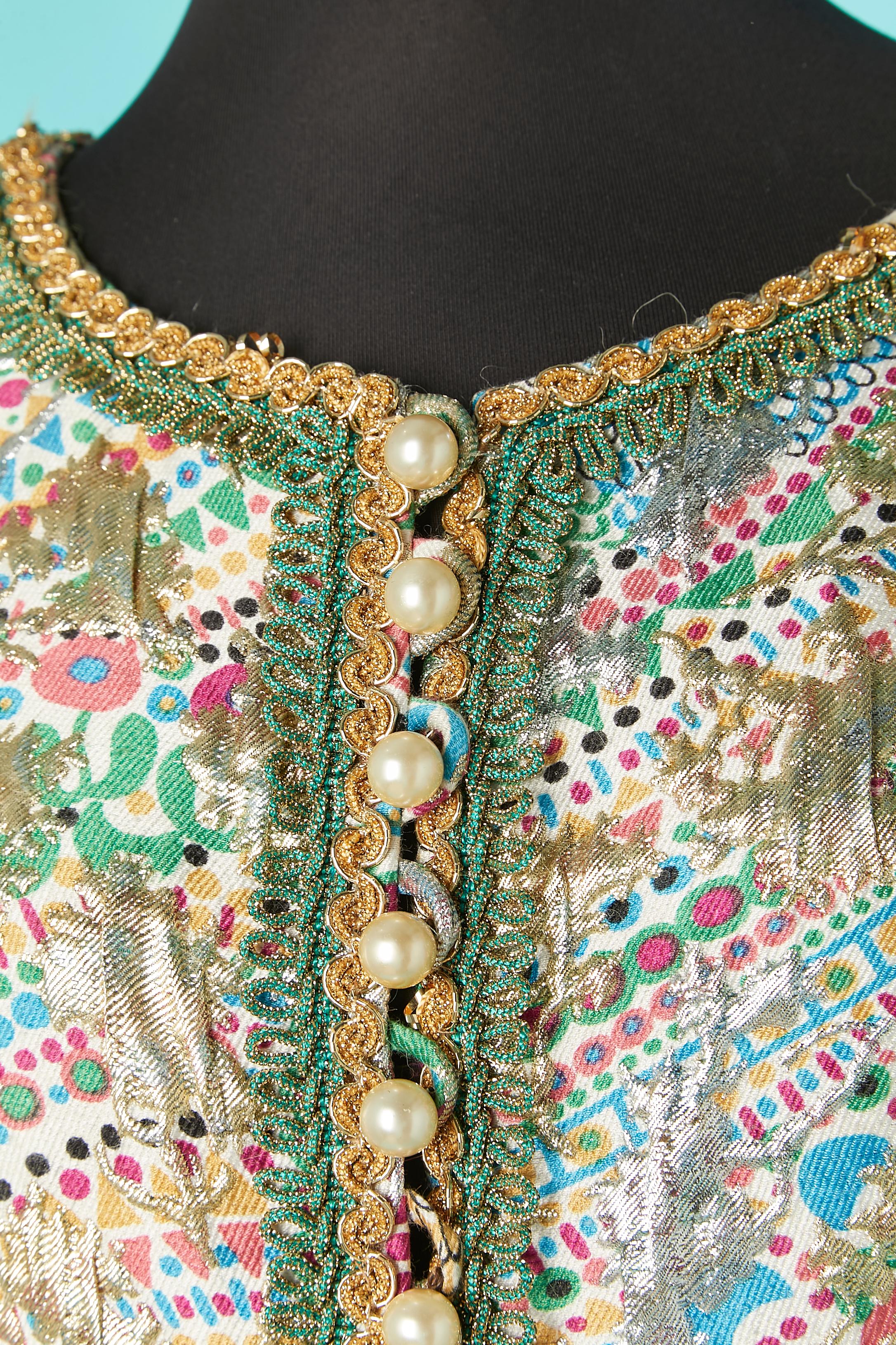 Robe de cocktail imprimée en brocart argenté et doré avec bouton en perle et passementerie en lurex sur le milieu du devant. 
Doublure en soie. 
TAILLE 38/40 (Fr) M/L 