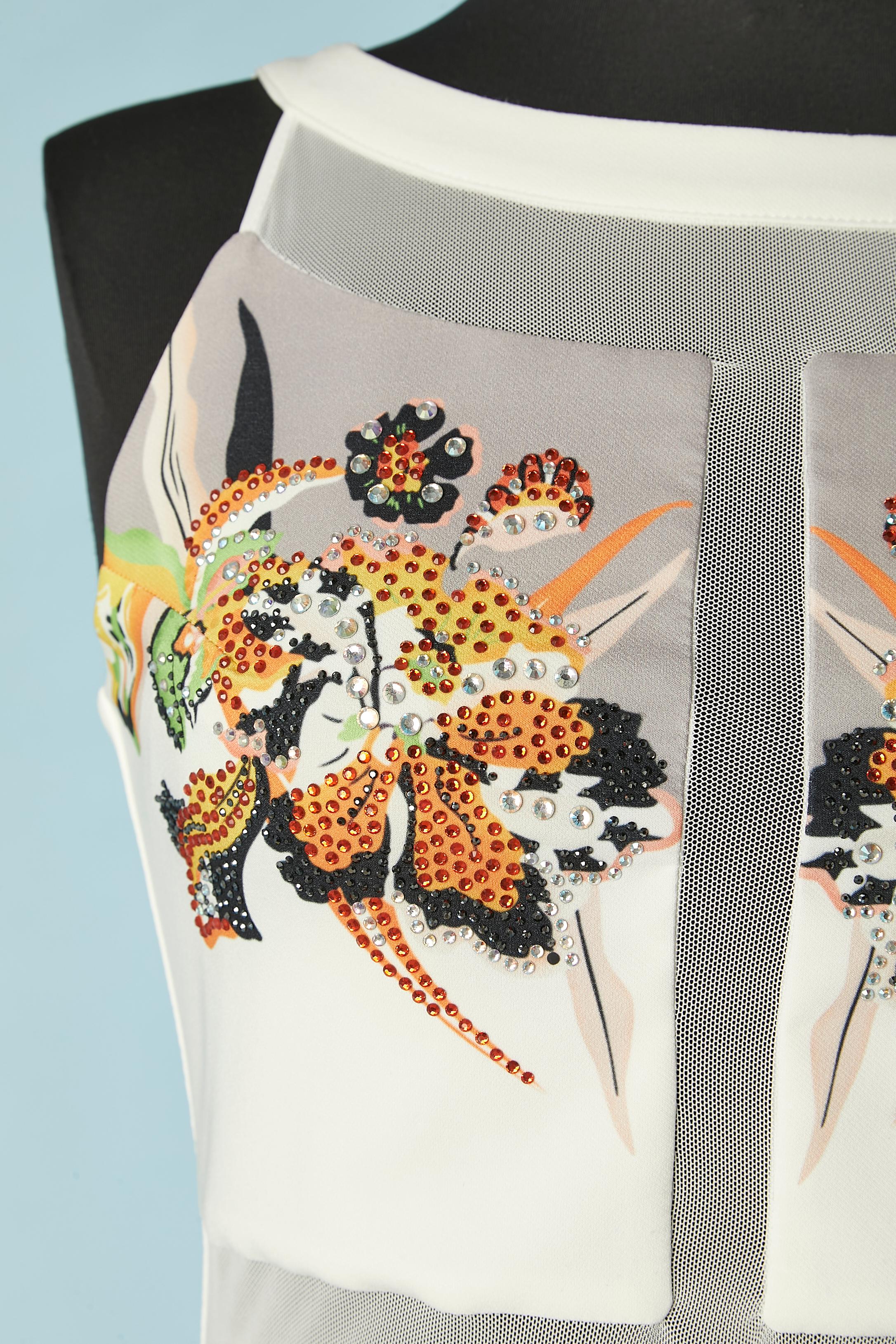 Abito da cocktail senza maniche stampato con strass e tulle. Composizione del tessuto principale: 92% poliestere, 8% lycra. Fodera: 100% poliestere. Tulle trasparente in vita, sulla scollatura e al centro della fronte. 
Zip nascosta nella parte
