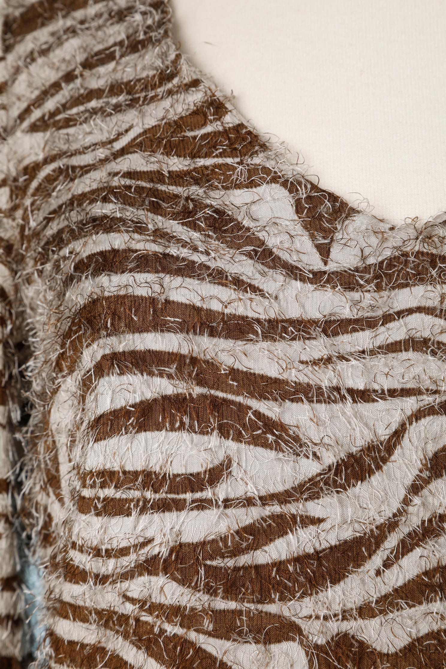 Printed dress with zebra print and thread fringes. Main fabric composition: 67% rayon, 33% silk. Lining: 92% silk, 8% elastane.
Split on both side. Zip and hook& eye closure on the middle back. 
SIZE 38 / M 
